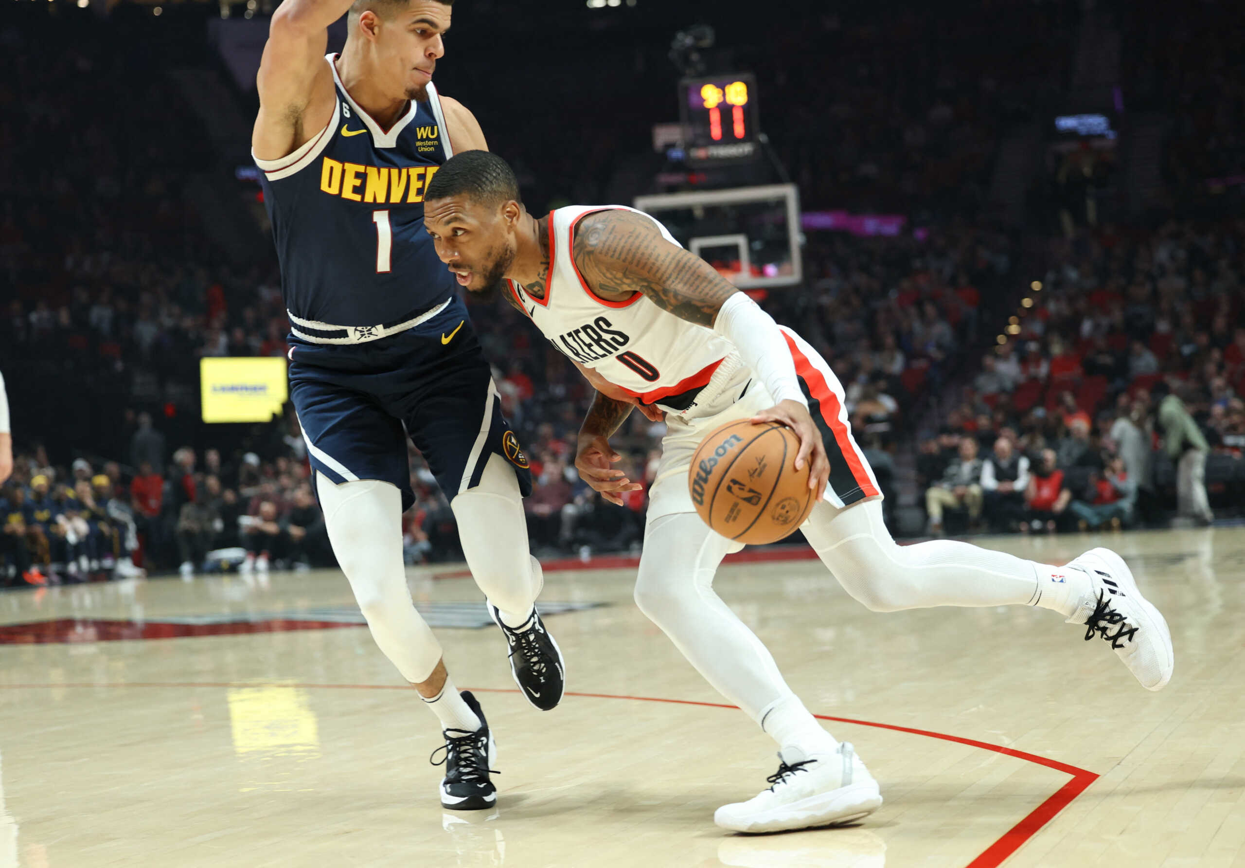 Oct 24, 2022; Portland, Oregon, USA; Portland Trail Blazers guard Damian Lillard (0) drives on Denver Nuggets forward Michael Porter Jr. (1) in the first half at Moda Center. Mandatory Credit: Jaime Valdez-USA TODAY Sports