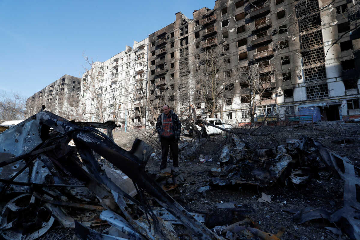 FILE PHOTO: Local resident and mechanic Vadim Tarasenko, 56, stands next to the wreckage of his car in the courtyard of an apartment building destroyed in the course of Ukraine-Russia conflict in the besieged southern port city of Mariupol, Ukraine March 28, 2022. REUTERS
