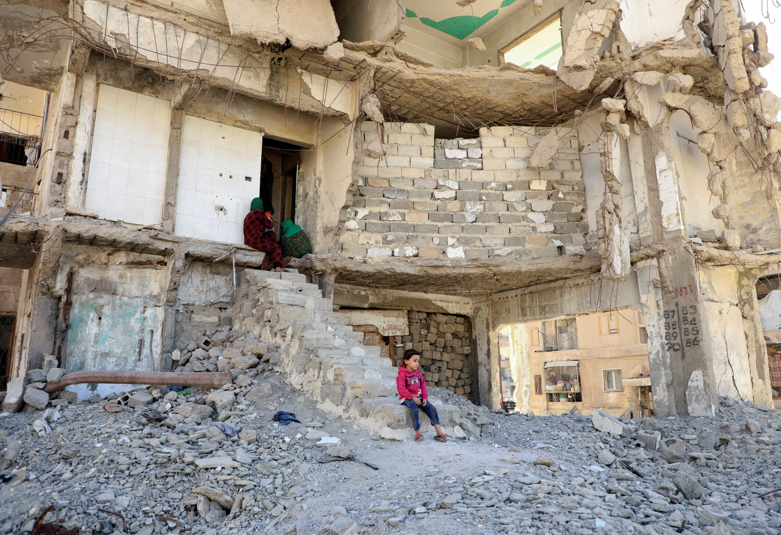 People sit in a damaged building in Raqqa, Syria October 12, 2022. REUTERS