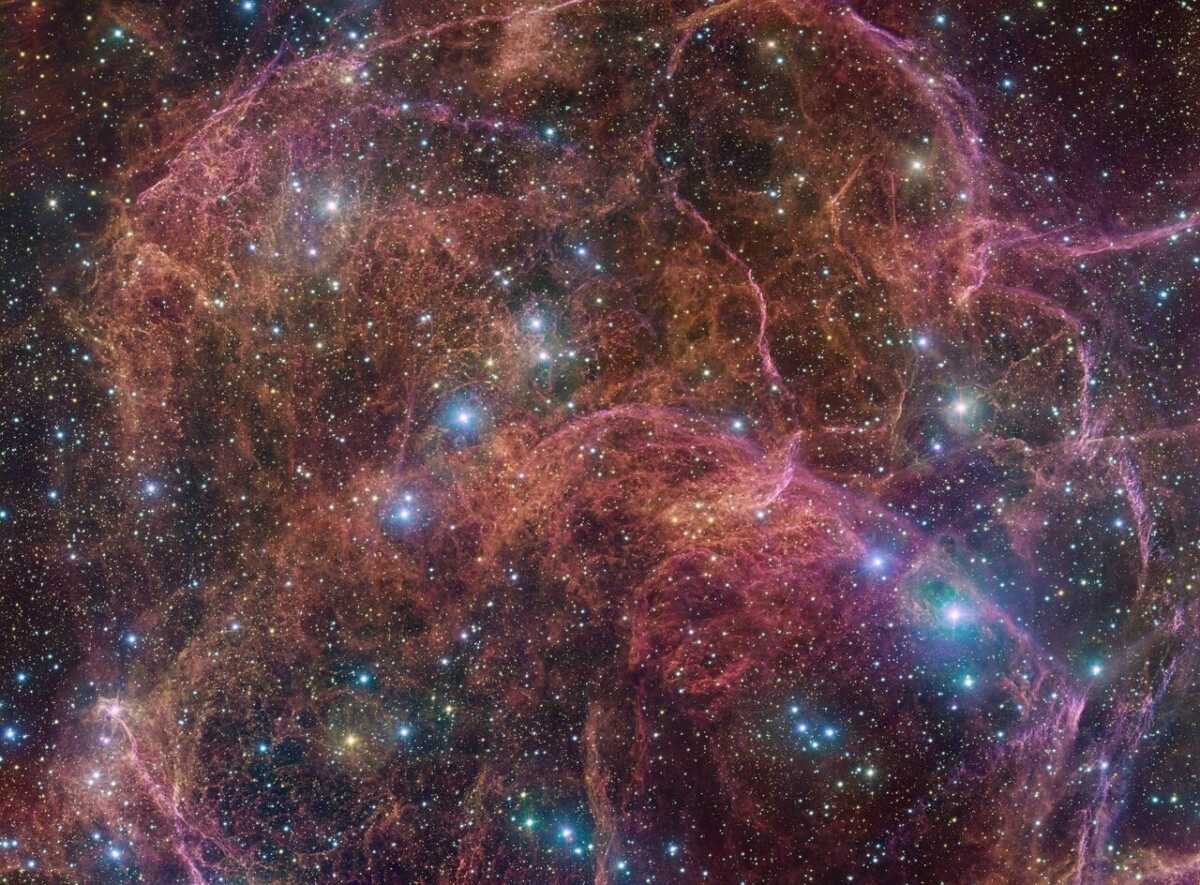 This image shows a spectacular view of the orange and pink clouds that make up what remains after the explosive death of a massive star — the Vela supernova remnant. This detailed image consists of 554 million pixels, and is a combined mosaic image of observations taken with the 268-million-pixel OmegaCAM camera at the VLT Survey Telescope, hosted at ESO’s Paranal Observatory.  OmegaCAM can take images through several filters that each let the telescope see the light emitted in a distinct colour. To capture this image, four filters have been used, represented here by a combination of magenta, blue, green and red. The result is an extremely detailed and stunning view of both the gaseous filaments in the remnant and the foreground bright blue stars that add sparkle to the image.