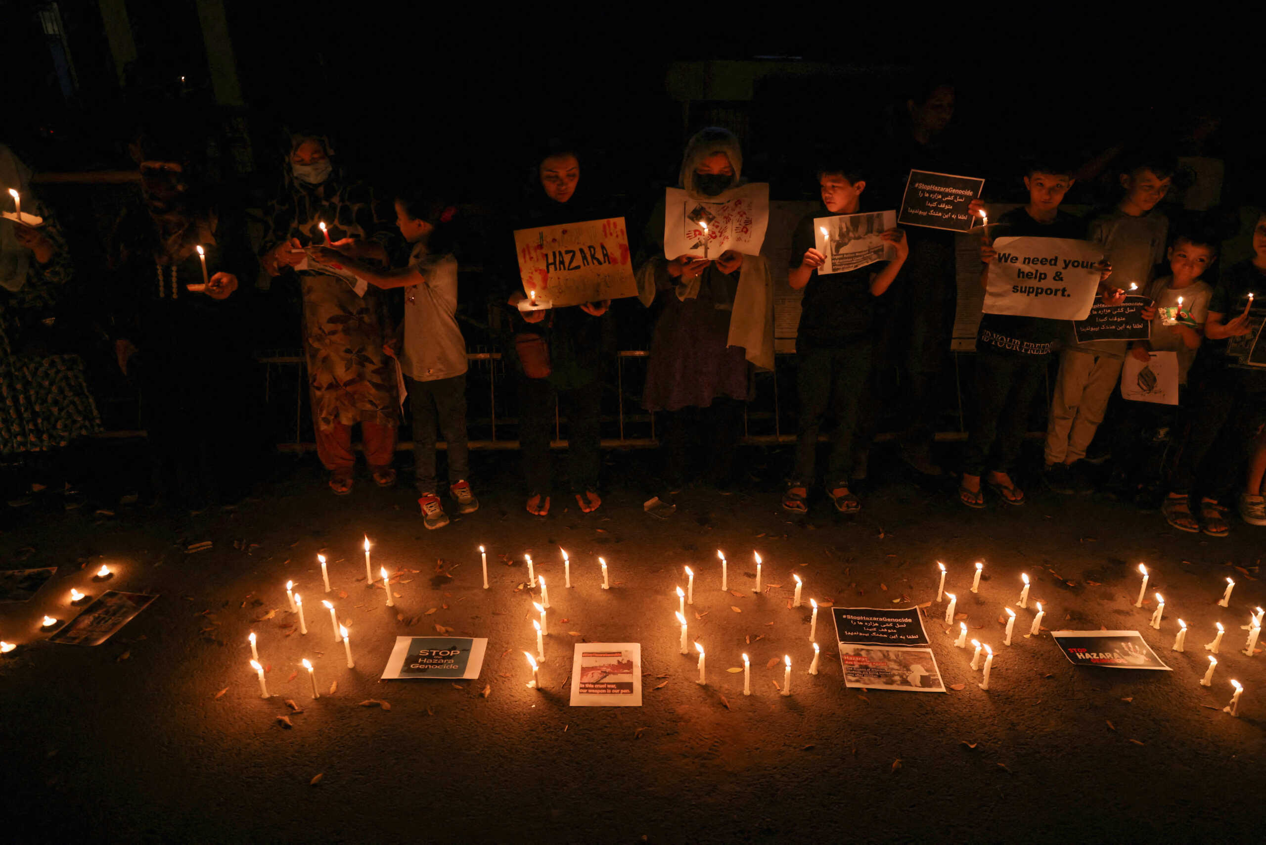 Afghan nationals, members of the Hazara minority, hold placards and candles as they protest against the suicide attack at a tutoring center in west Kabul, outside the United Nations High Commissioner for Refugees (UNHCR) office, in New Delhi, India, September 30, 2022. REUTERS