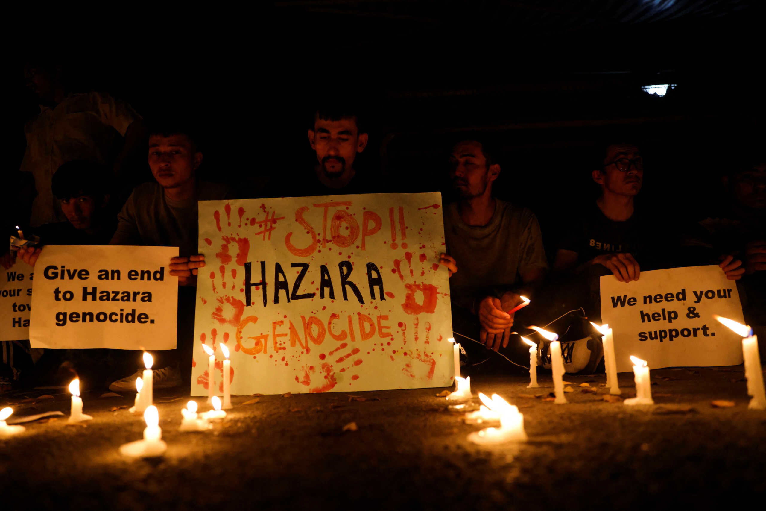 Afghan nationals, members of the Hazara minority hold placards and candles as they protest against the suicide attack at a tutoring center in west Kabul, outside the United Nations High Commissioner for Refugees (UNHCR) office, in New Delhi, India, September 30, 2022. REUTERS