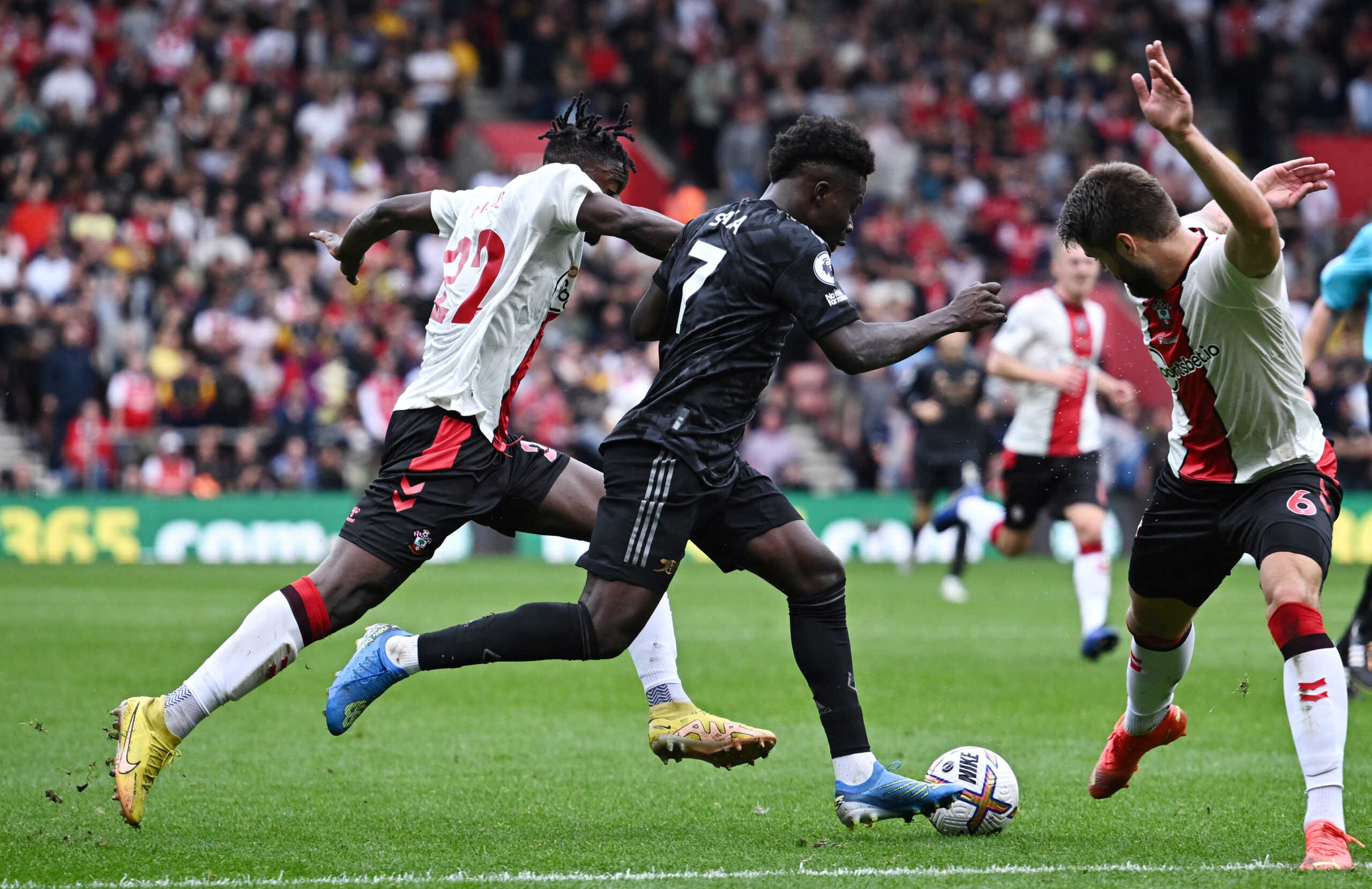 Soccer Football - Premier League - Southampton v Arsenal - St Mary's Stadium, Southampton, Britain - October 23, 2022 Arsenal's Bukayo Saka in action with Southampton's Mohammed Salisu and Duje Caleta-Car REUTERS