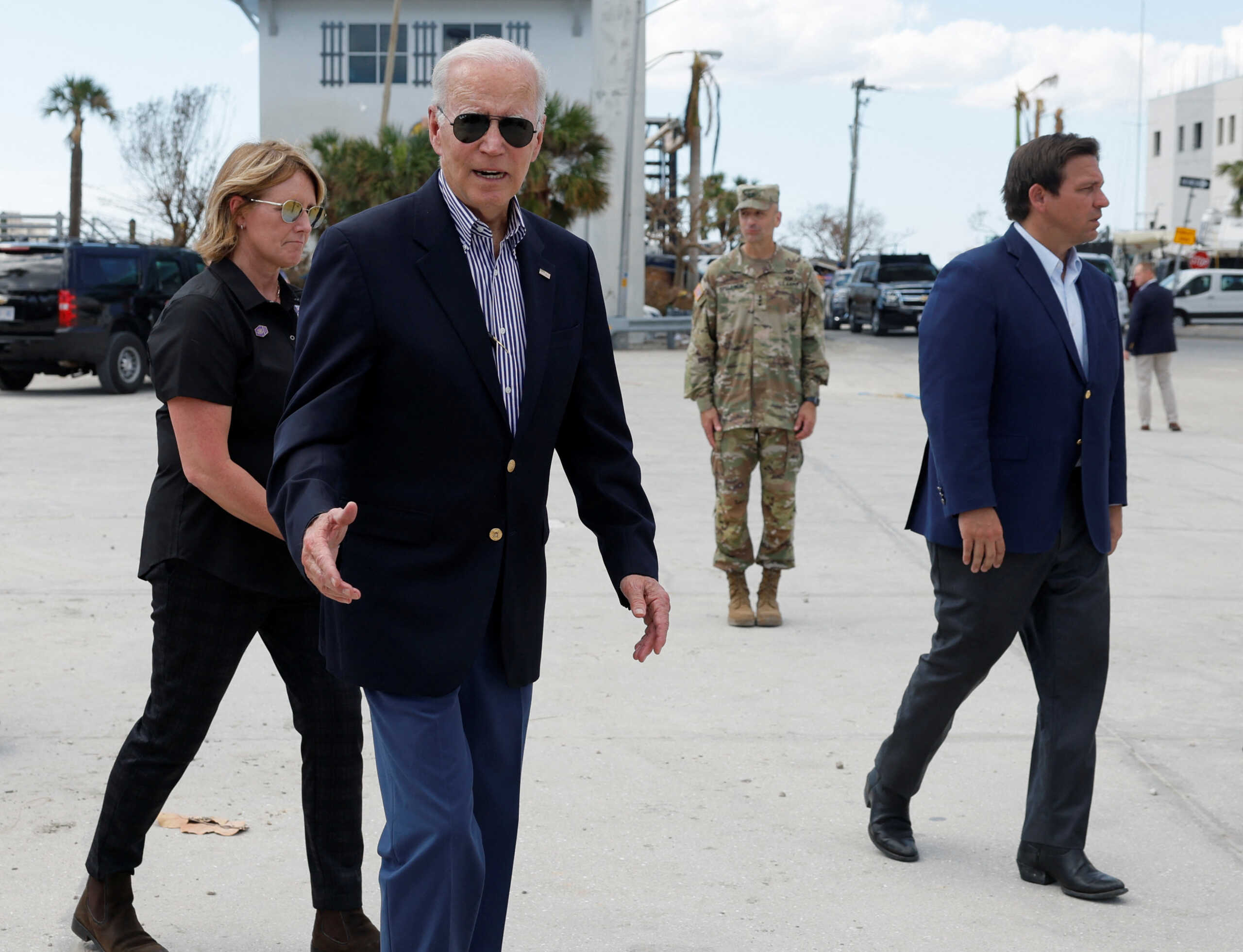 U.S. President Joe Biden walks next to Florida governor Ron DeSantis as he tours Hurricane Ian destruction during a visit to Florida, in Fort Myers Beach, Florida, U.S., October 5, 2022.  REUTERS