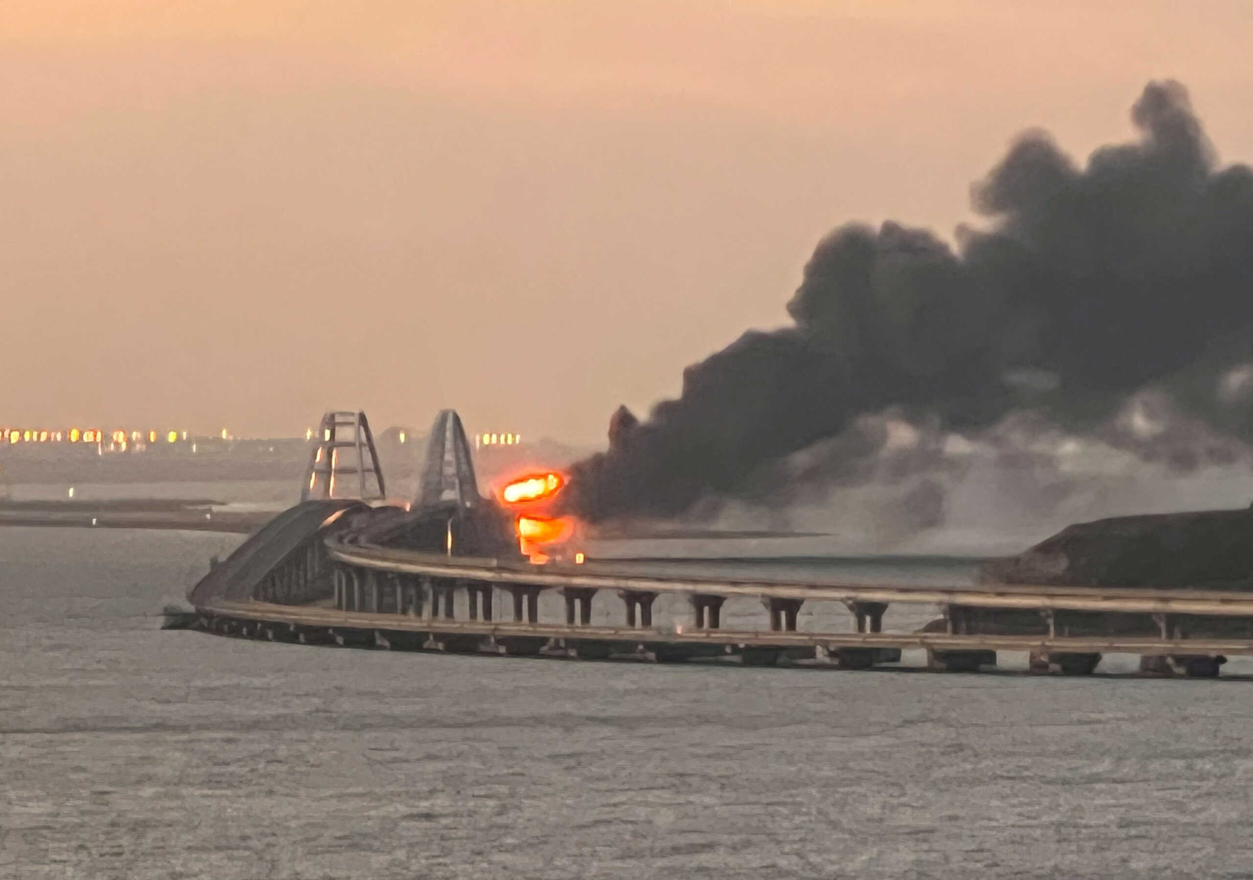 A view shows a fire on the Kerch bridge at sunrise in the Kerch Strait, Crimea, October 8, 2022.  REUTERS