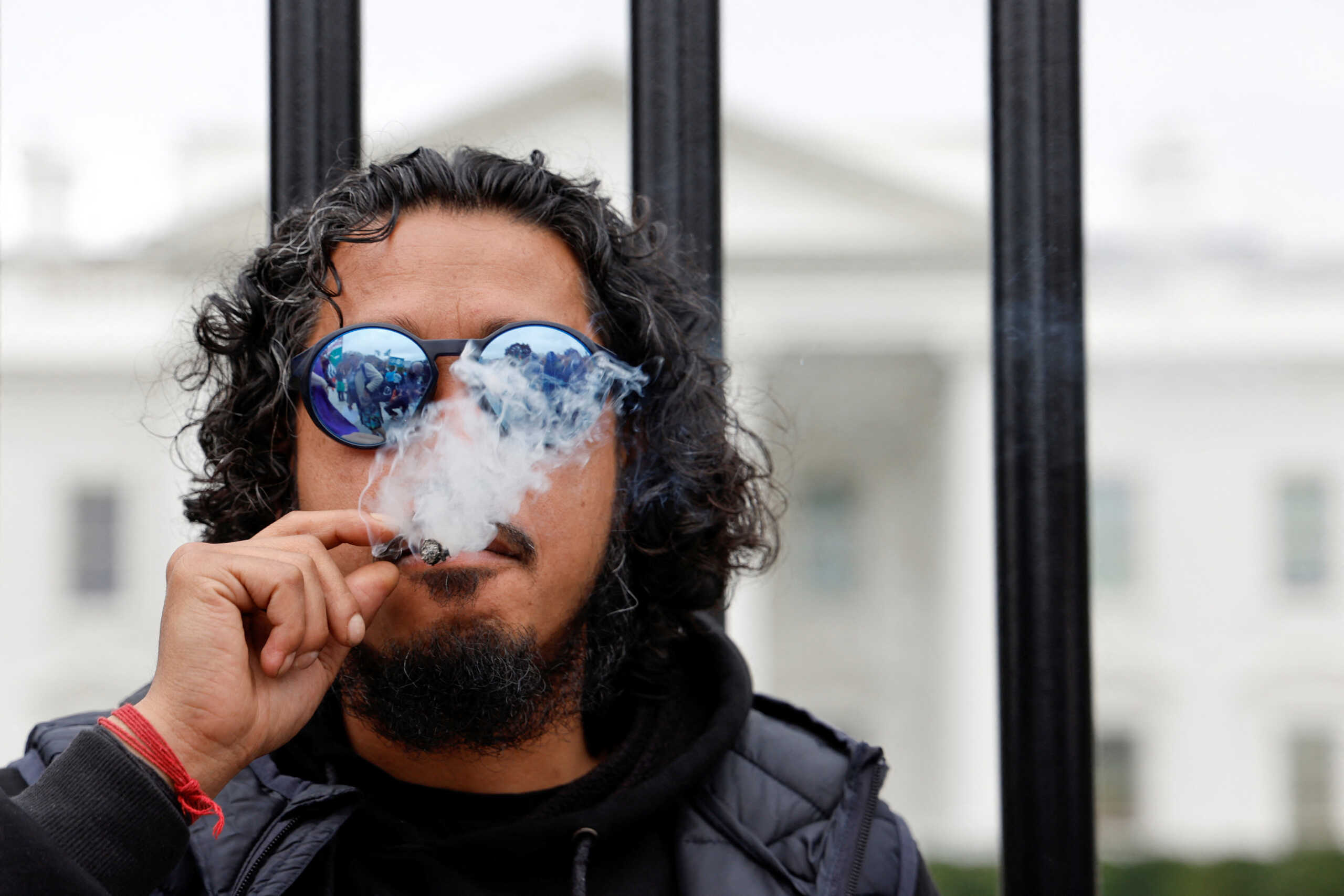 Pro-cannibis activist Hemant Shahi Ne smokes at the White House gates during a rally urging U.S. President Joe Biden to release all prisoners convicted of marijuana-related charges, outside of the White House in Washington, U.S. October 24, 2022.  REUTERS