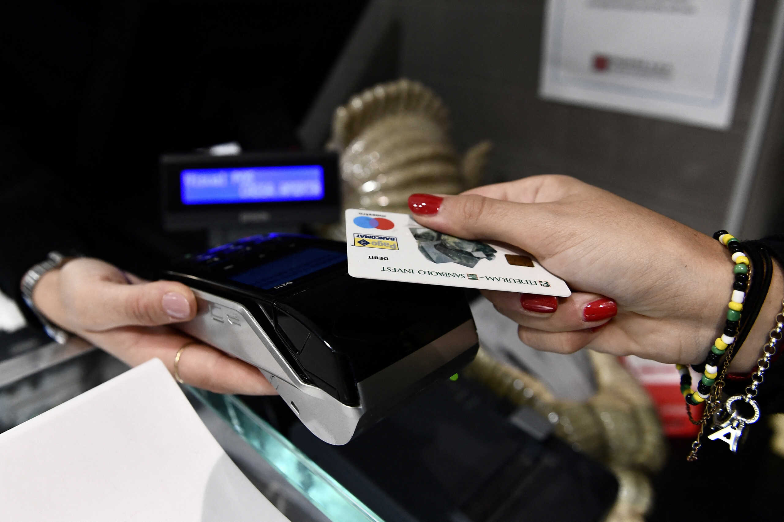 FILE PHOTO: A woman uses her card to pay the bill in a restaurant in Milan, Italy, October 2, 2020. Picture taken October 2, 2020. REUTERS