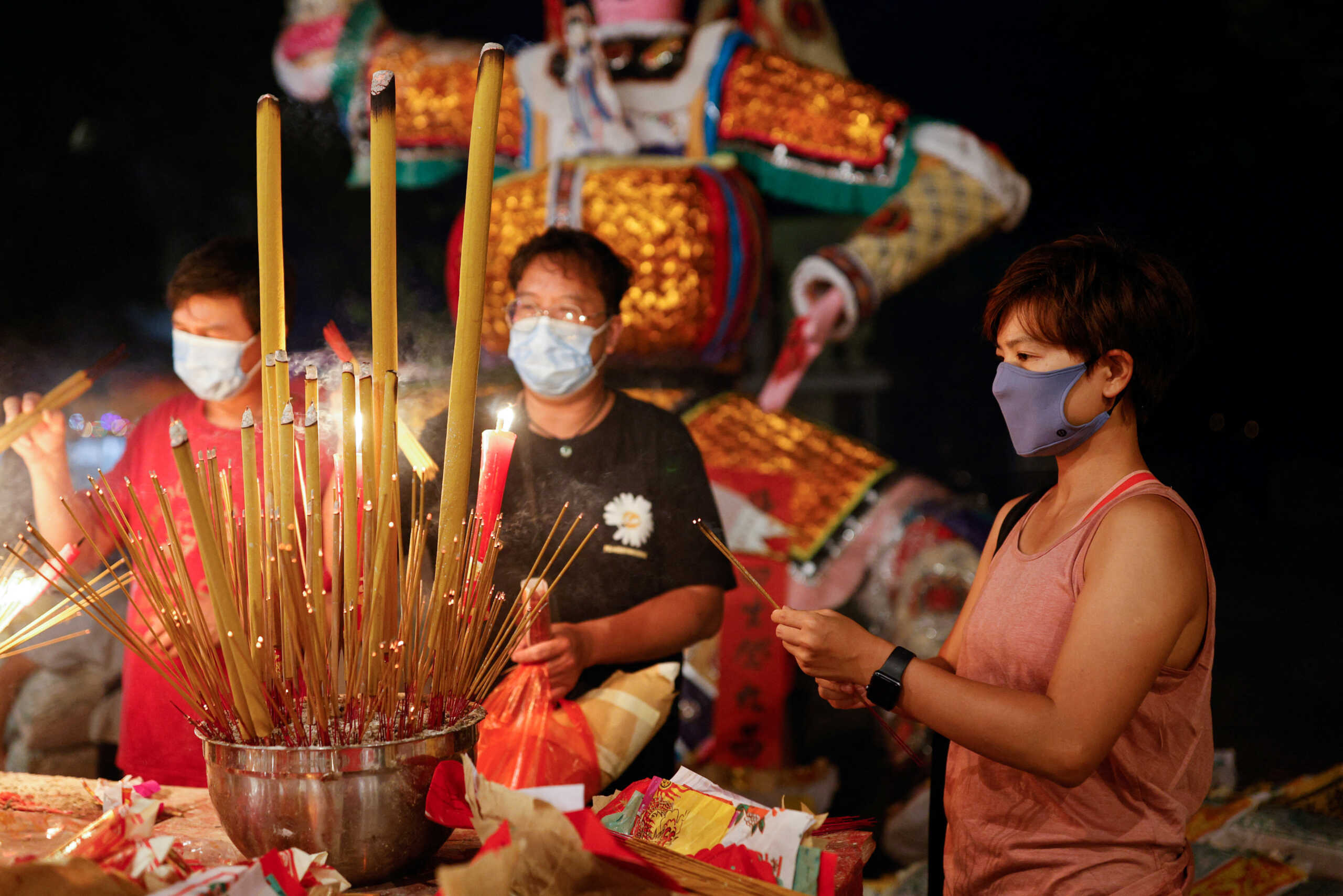 Yoga teacher Zero Chan, 36, prays during the Hungry Ghost Festival, on Peng Chau island in Hong Kong, China August 19, 2022. The island offers valuable middle ground for some like Chan, who seek to leave behind the stress accumulated from events such as pro-democracy protests in 2019, a national security crackdown that followed, and more recently, strict curbs against COVID-19.    REUTERS