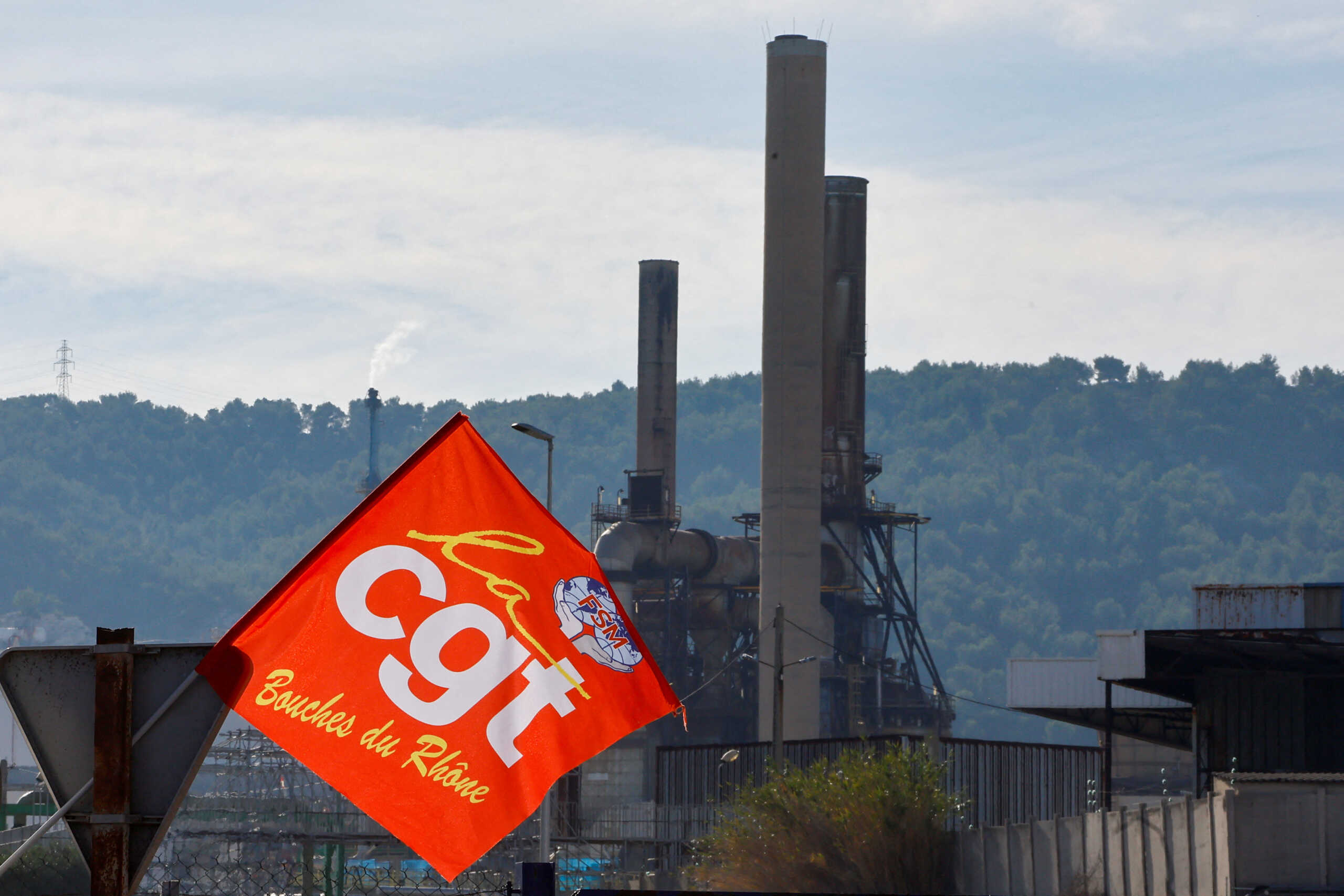 A flag of CGT union flies as people gather during a TotalEnergies and Esso ExxonMobil workers' protest outside TotalEnergies refinery in La Mede, France October 11, 2022. REUTERS