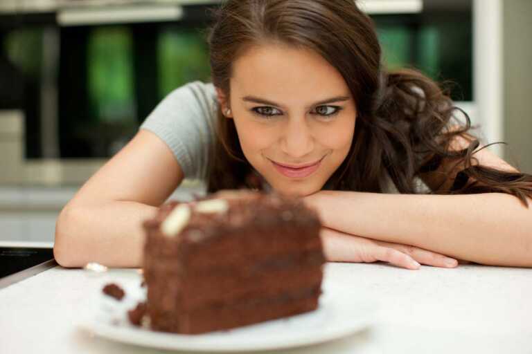 γυναίκα κοιτάει ένα σοκολατένιο γλυκό
