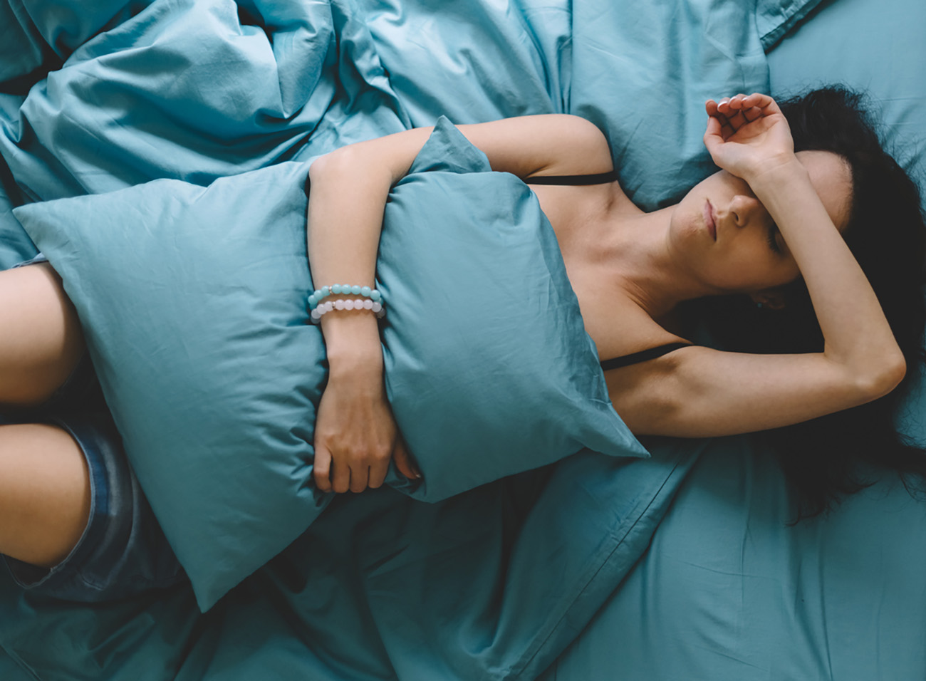 Depressed woman in bed with hand on forehead