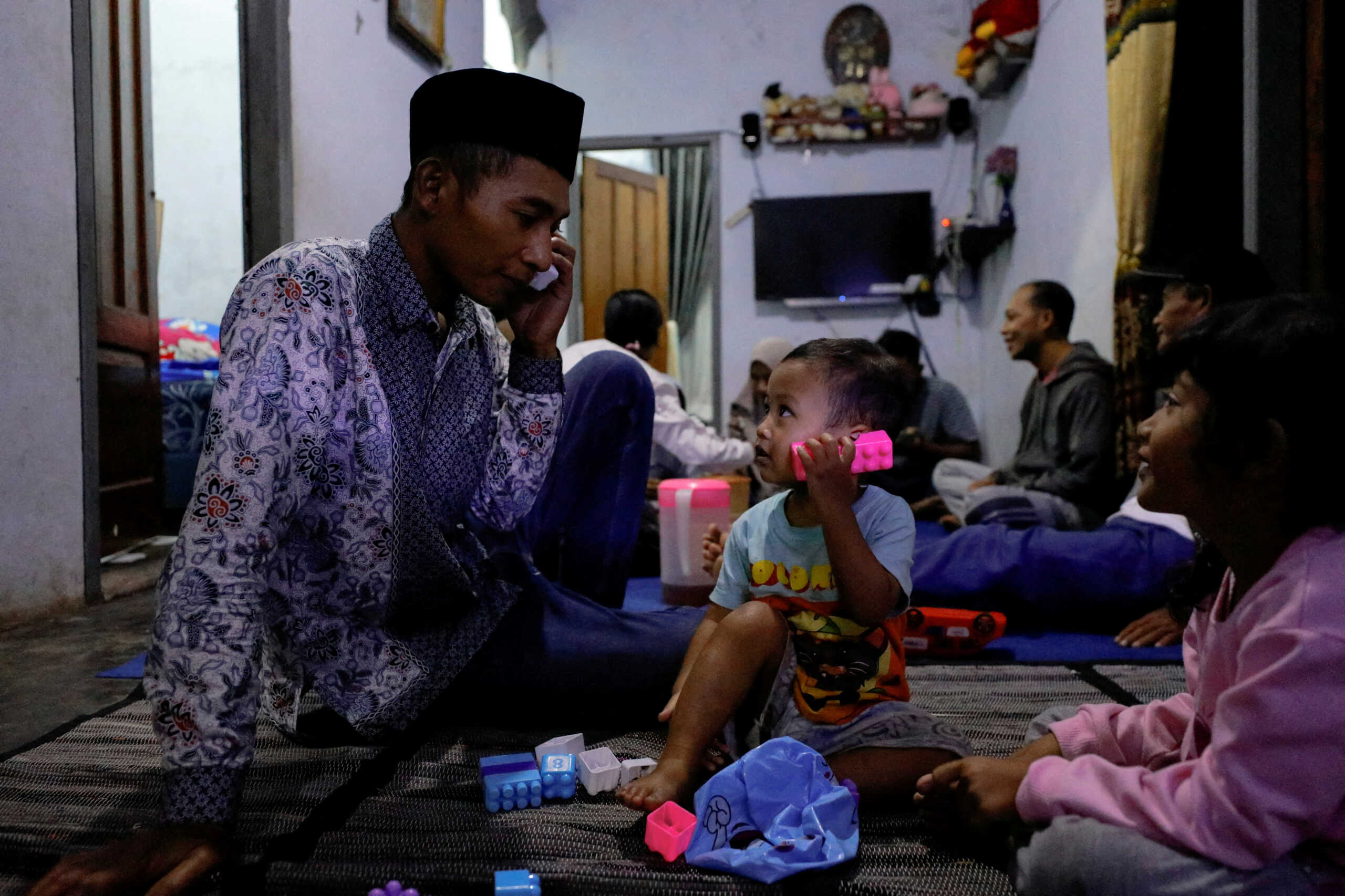 Andi Hariyanto, 36, a husband who lost his wife and two adopted children in a recent riot and stampede following a soccer match between Arema FC and Persebaya Surabaya at Kanjuruhan stadium, plays with his 2-year-old son Gean Putra Hariyanto, at his house in Malang, East Java province, Indonesia, October 4, 2022. REUTERS