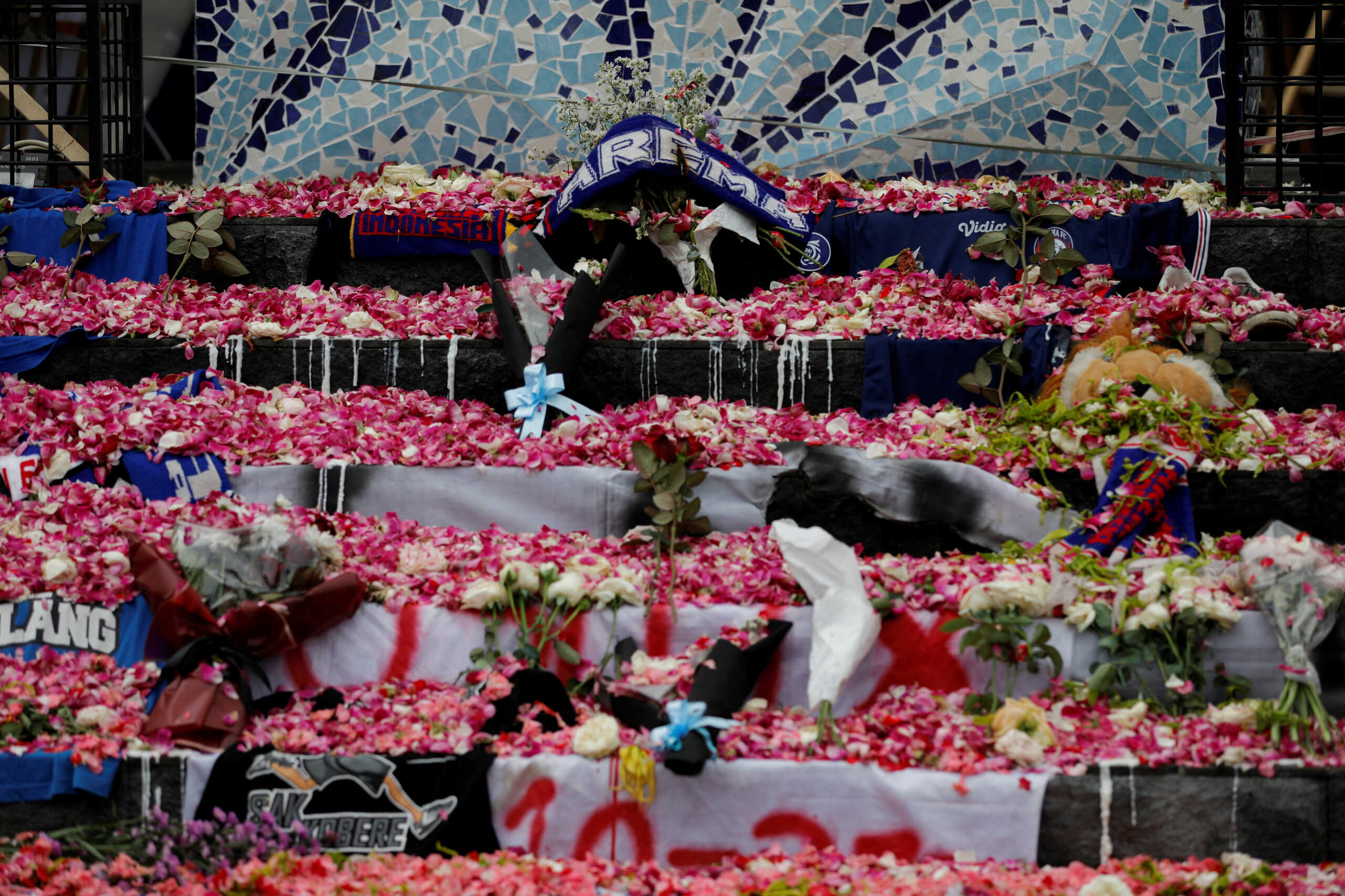 Petals and Arema FC supporters' tributes are placed on a monument to pay condolence to the victims of a riot and stampede following a soccer match between Arema FC and Persebaya Surabaya teams, outside the Kanjuruhan Stadium, in Malang, East Java province, Indonesia, October 3, 2022. REUTERS