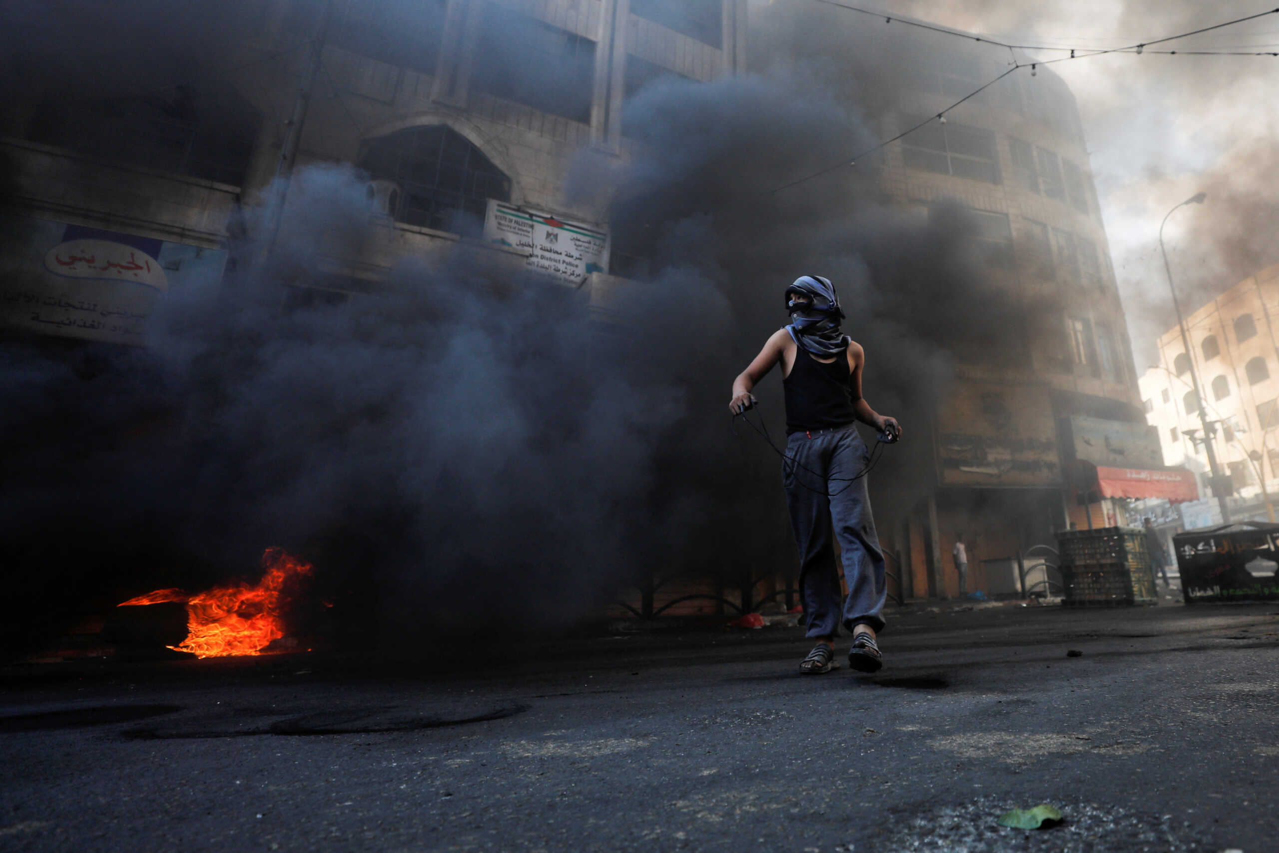 A Palestinian man holds a slingshot amid clashes with Israeli forces during a protest in Hebron in the Israeli-Occupied West Bank October 14, 2022. REUTERS