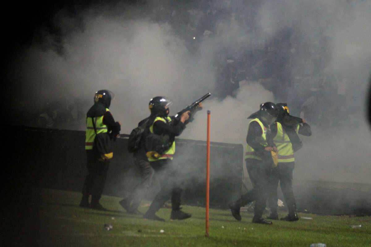 A riot police officer fires tear gas during a riot after the league BRI Liga 1 football match between Arema vs Persebaya at Kanjuruhan Stadium in Malang, East Java province, Indonesia, October 2, 2022, in this photo taken by Antara Foto. Antara Foto