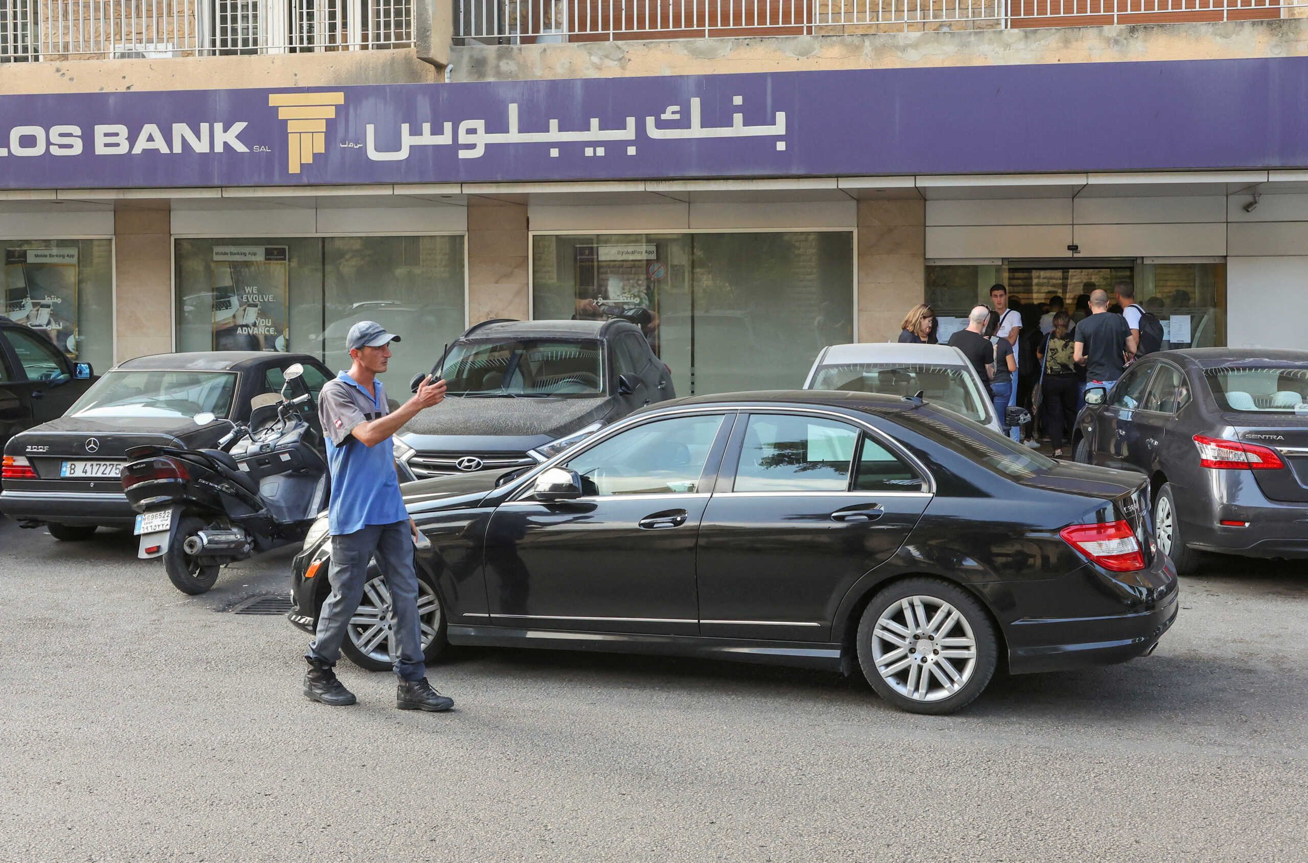 People stand outside a Byblos bank branch in Antelias, Lebanon October 5, 2022. REUTERS