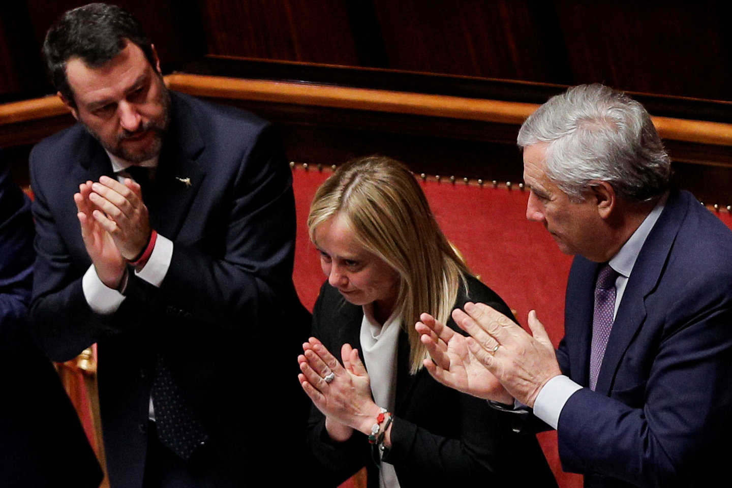 Italy's Foreign Affairs Minister Antonio Tajani and Infrastructure Minister Matteo Salvini applaud as Prime Minister Giorgia Meloni gestures during a session of the upper house of parliament ahead of a confidence vote for the new government, in Rome, Italy, October 26, 2022. REUTERS