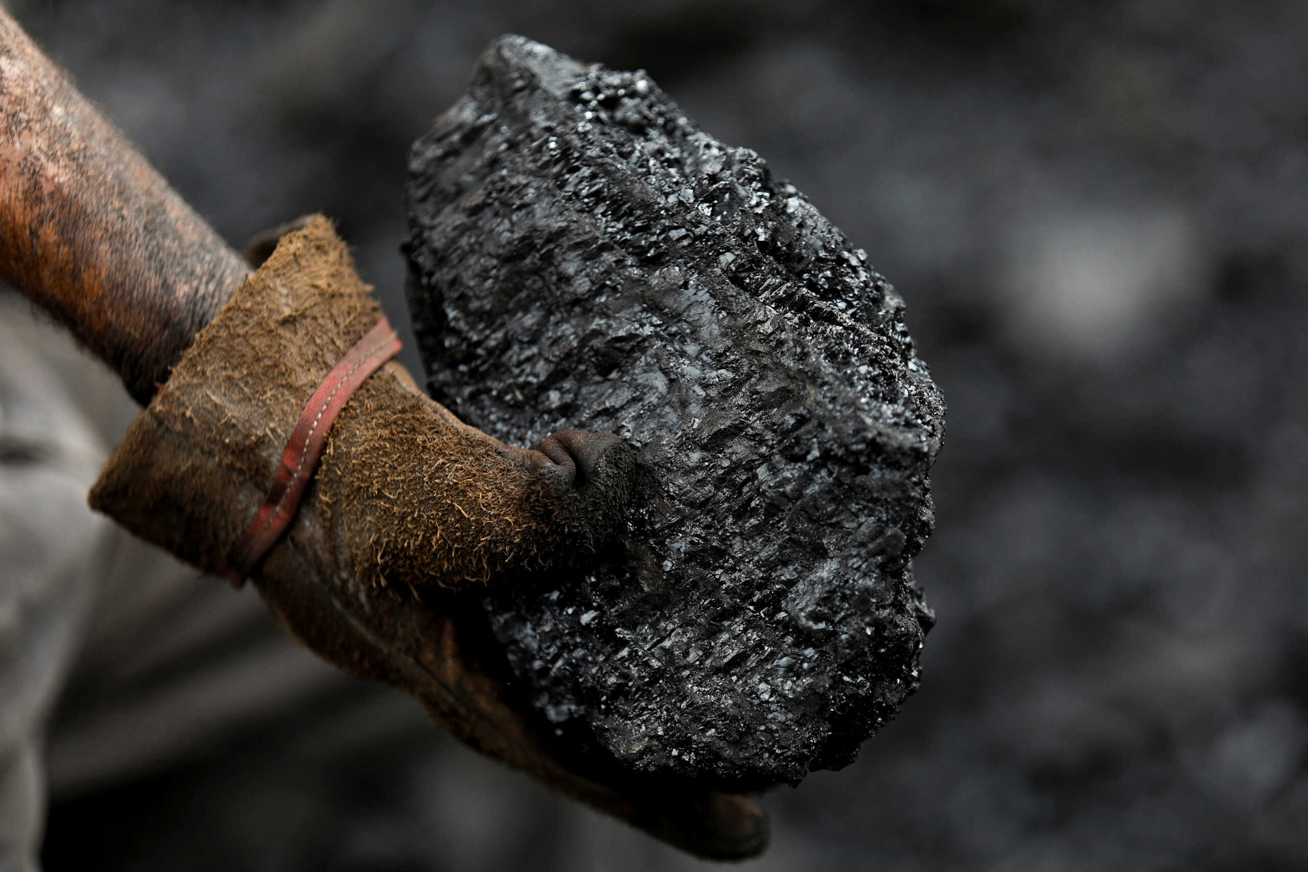 A miner holds a piece of coal that was extracted from a coal mine, in Sabinas, Mexico August 19, 2022. On August 3, 10 miners were trapped in the nearby coal mine of El Pinabete as water broke through a shaft wall and flooded the tunnels the men were working in. Nearly two months later, their bodies have still not been recovered.     REUTERS