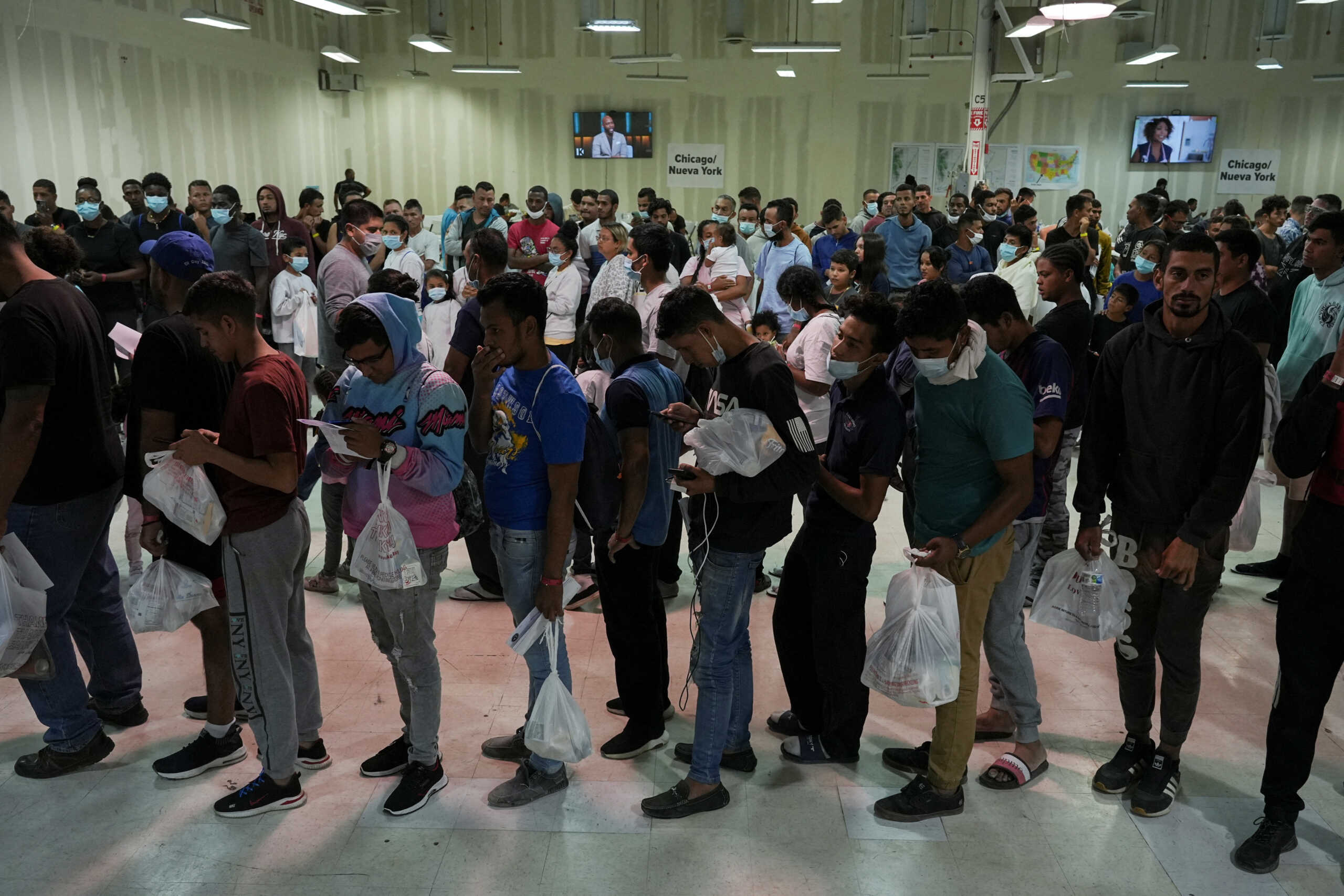 Asylum-seeking migrants wait in line before boarding buses to New York and Chicago at the Migrant Welcome Center managed by the city of El Paso and the Office of Emergency Management, in El Paso, Texas, U.S., October 3, 2022. REUTERS