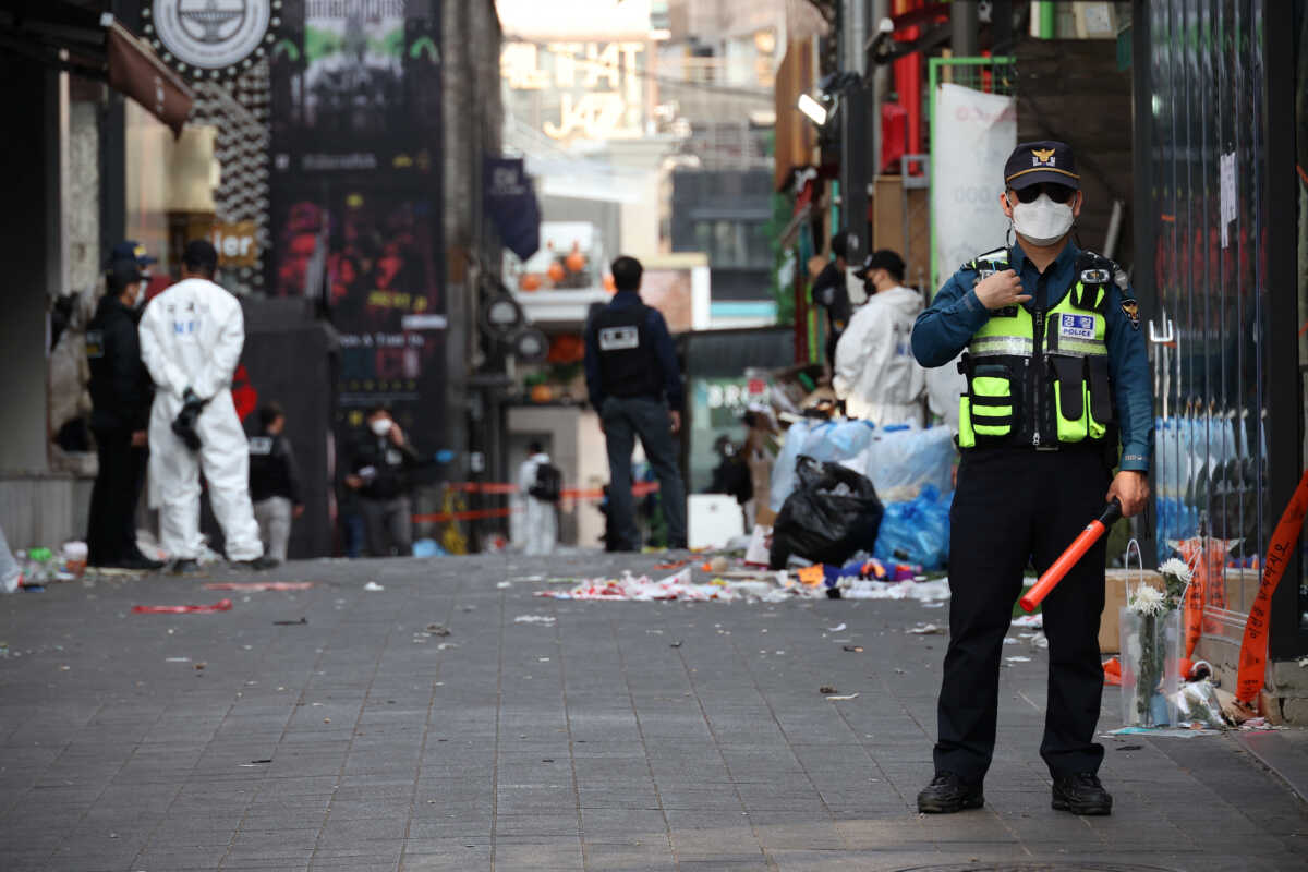 A member of the police stands guard while investigators inspect the scene of a stampede that happened during Halloween festivities, in Seoul, South Korea October 31, 2022. REUTERS