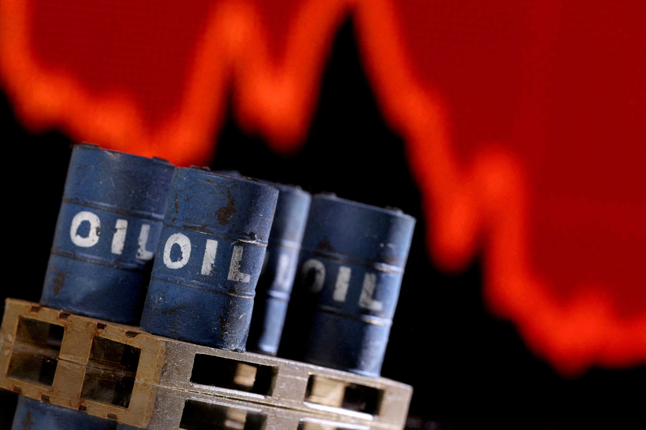 FILE PHOTO: A model of 3D printed oil barrels is seen in front of displayed stock graph going down in this illustration taken, December 1, 2021. REUTERS