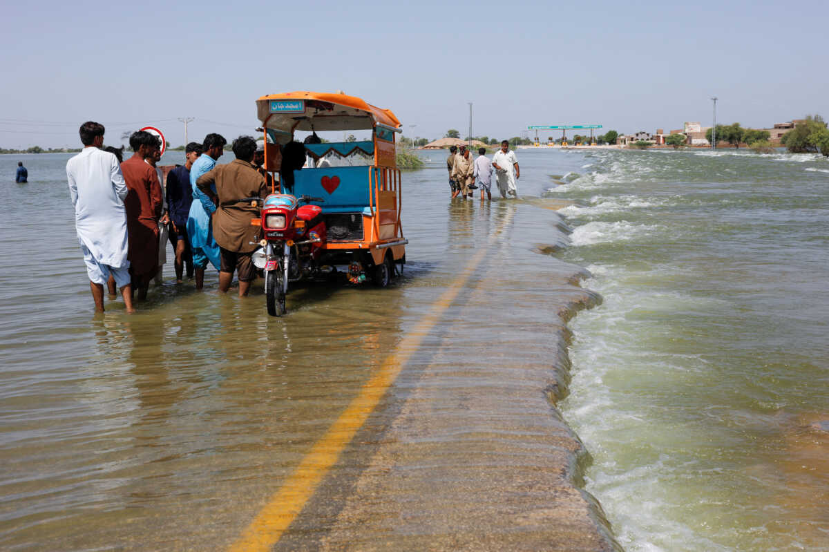 Displaced people stand on flooded highway, following rains and floods during the monsoon season in Sehwan, Pakistan, September 16, 2022. REUTERS