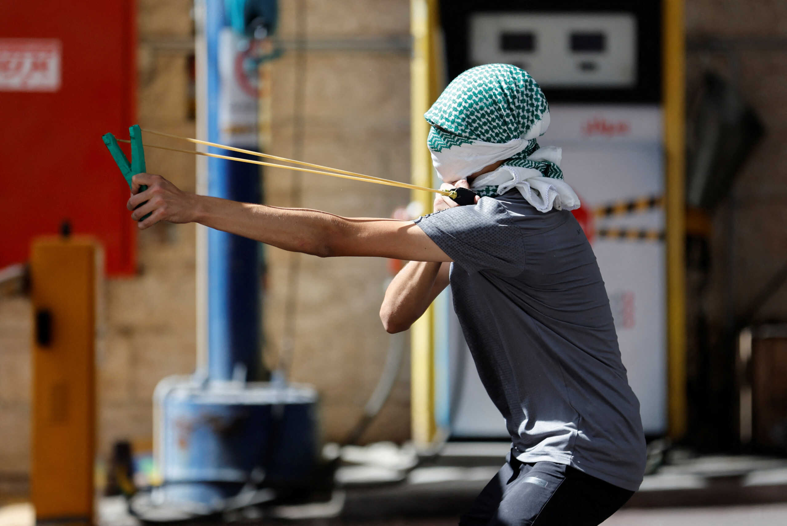 A man shoots a slingshot during a Palestinian protest over the  killing of Palestinian gunmen in an Israeli raid on Wednesday, in Hebron in the Israeli-occupied West Bank September 29, 2022. REUTERS