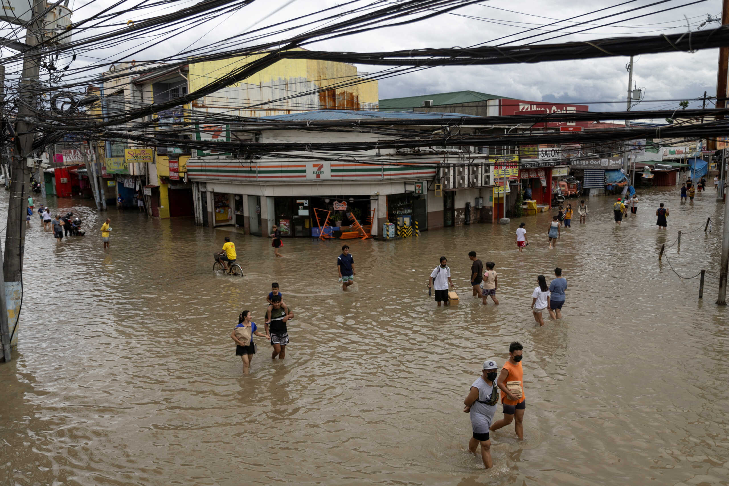 People wade through flooded streets following heavy rains tropical storm Nalgae, in Imus, Cavite province, Philippines, October 30, 2022. REUTERS