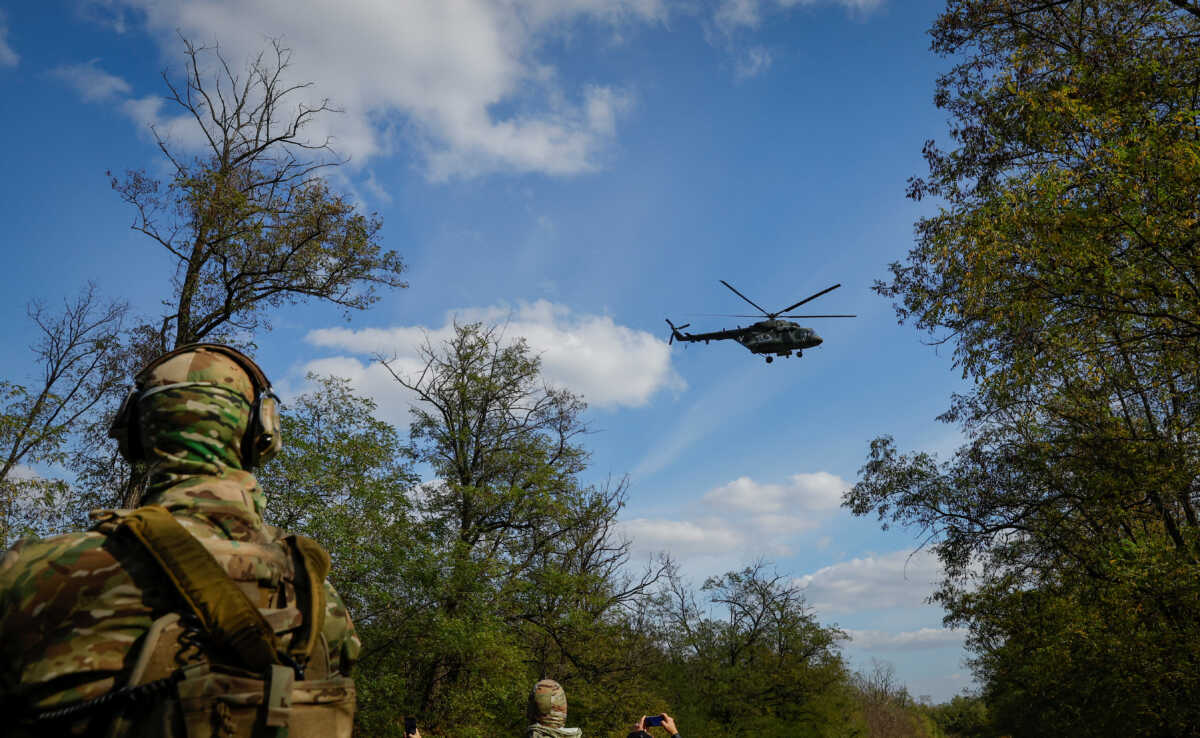 A Russian army helicopter flies above, as volunteers of a newly formed battalion take part in a training at a range outside the city of Melitopol, Russian-controlled Ukraine October 13, 2022. REUTERS