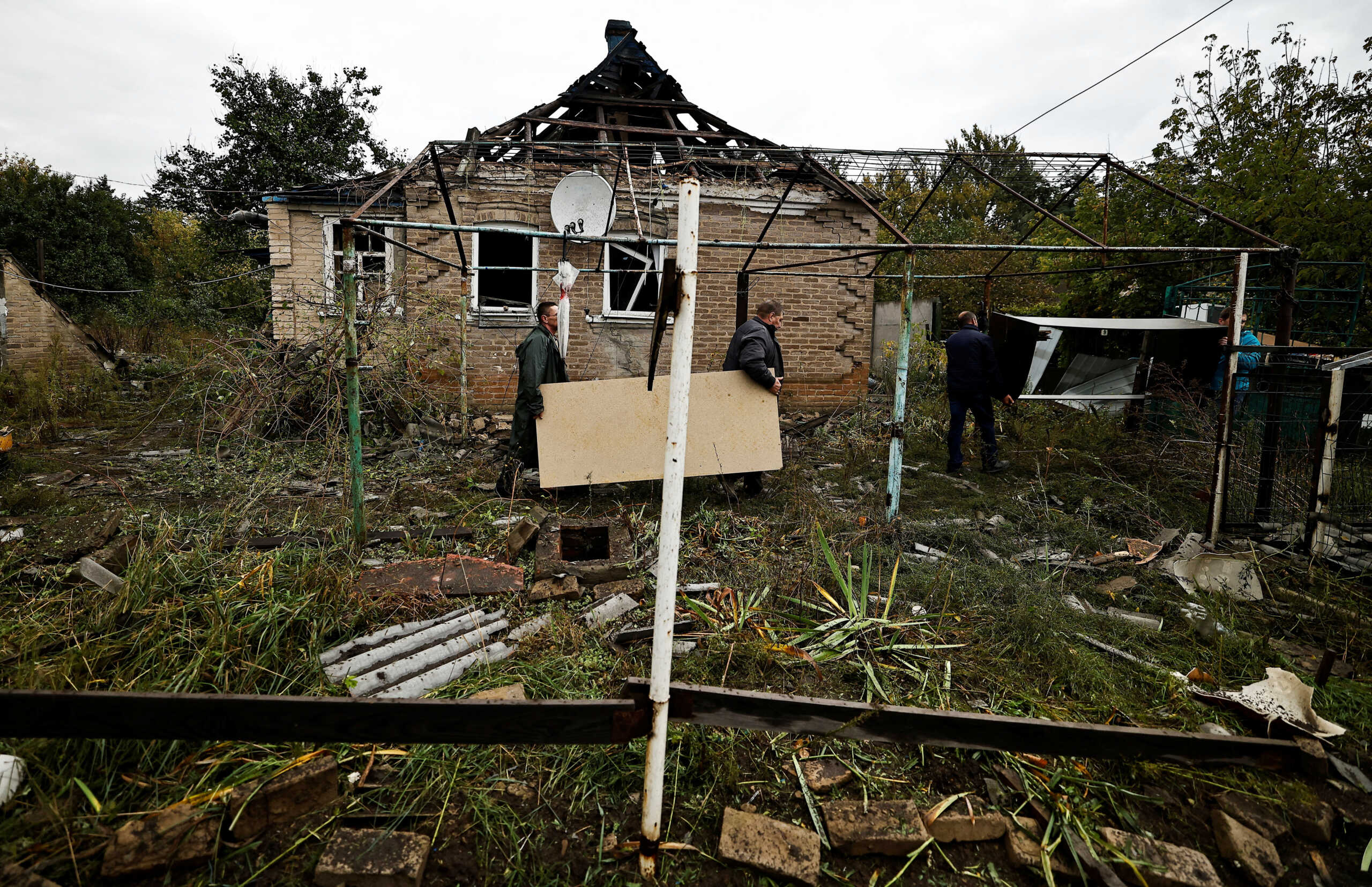 Vladimir Reuka takes belongings out from his son's house following a Russian missile strike, as Russia's attack on Ukraine continues, in Kramatorsk, Donetsk region, Ukraine, October 4, 2022. REUTERS