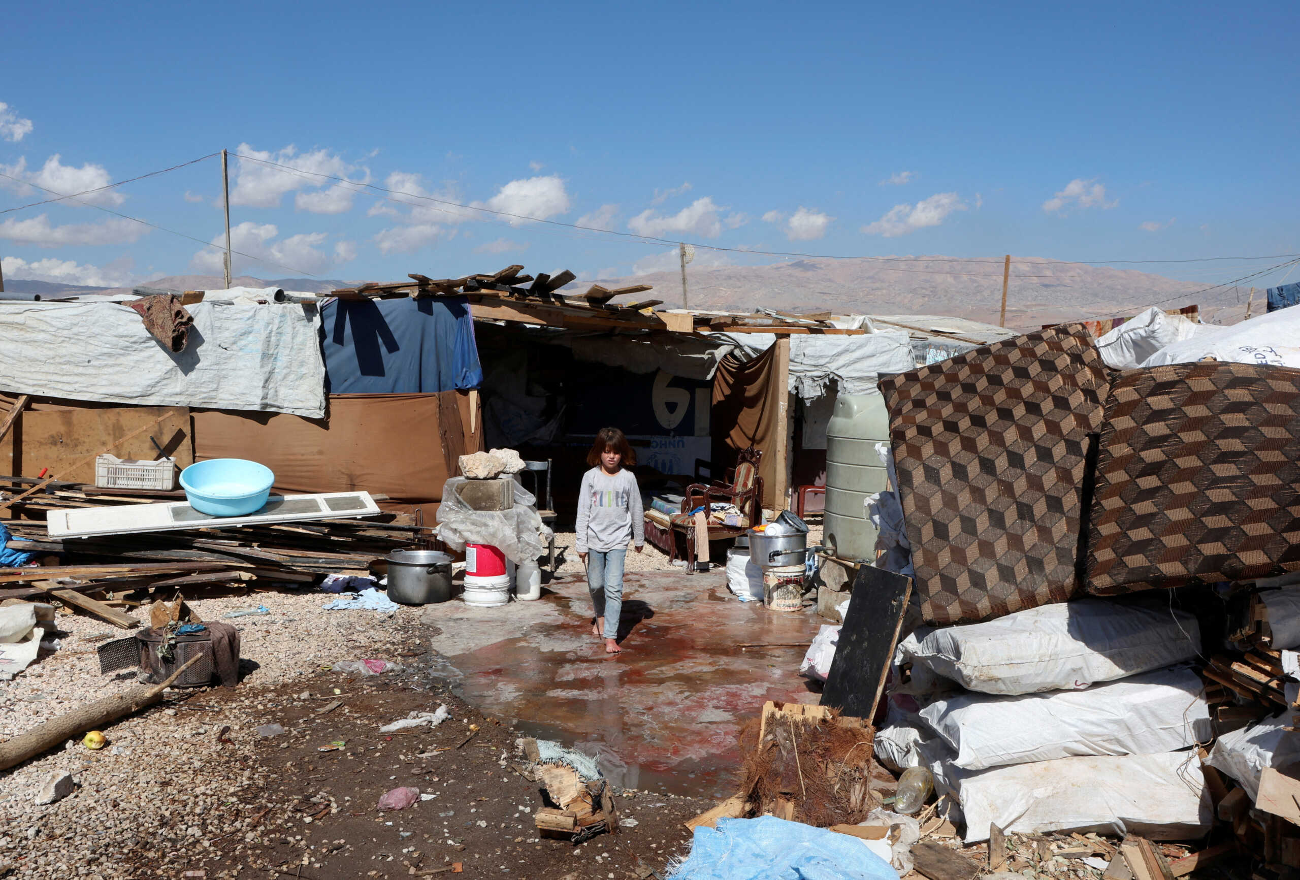 A girl walks outside tents at an informal camp for Syrian refugees in Qab Elias, in Lebanon's Bekaa Valley October 18, 2022. REUTERS