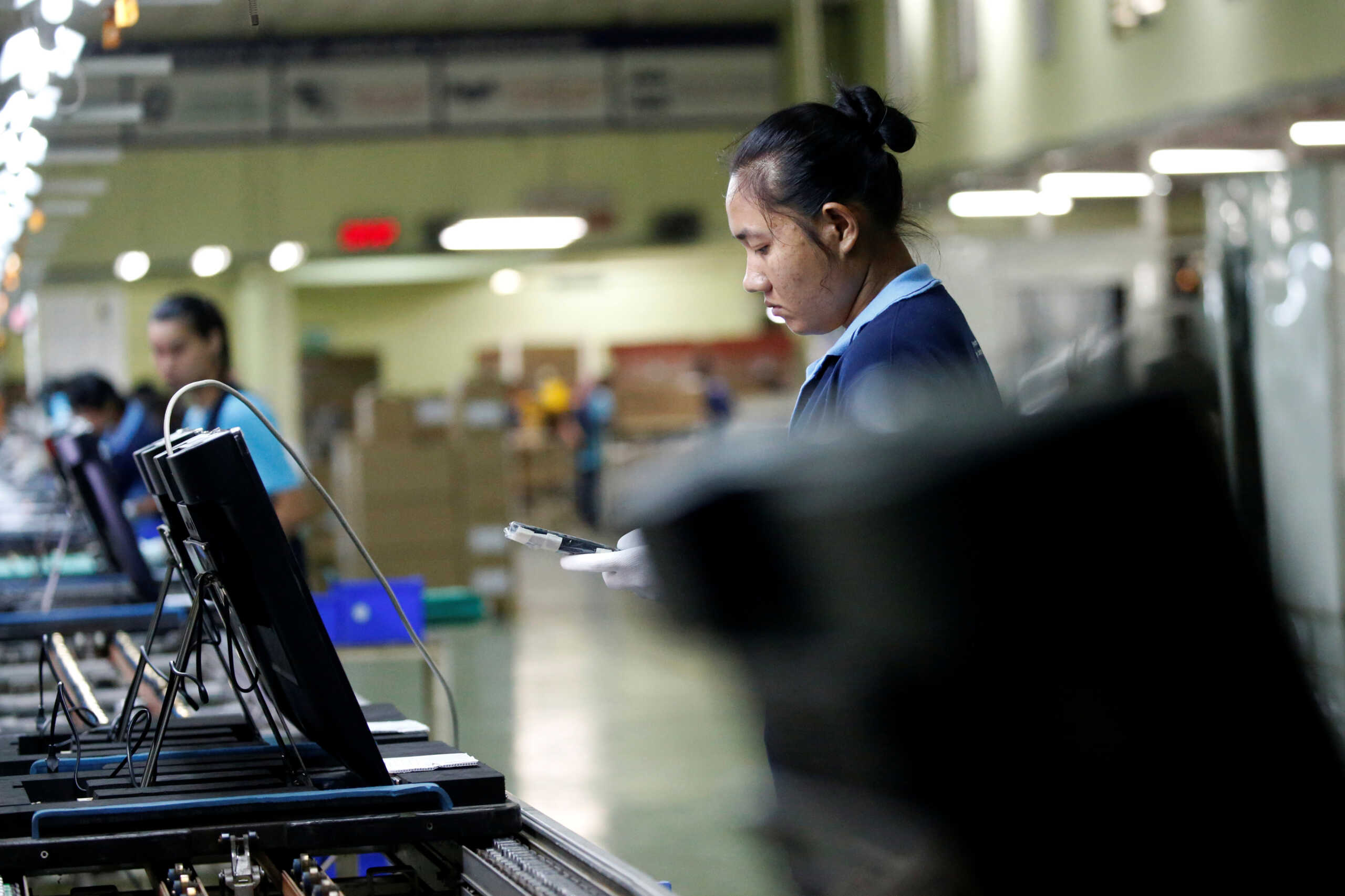 Migrant workers from Myanmar test the quality of monitors as they work on a TV assembly line at a factory in Bangkok, Thailand July 22, 2019. Picture taken July 22, 2019. REUTERS