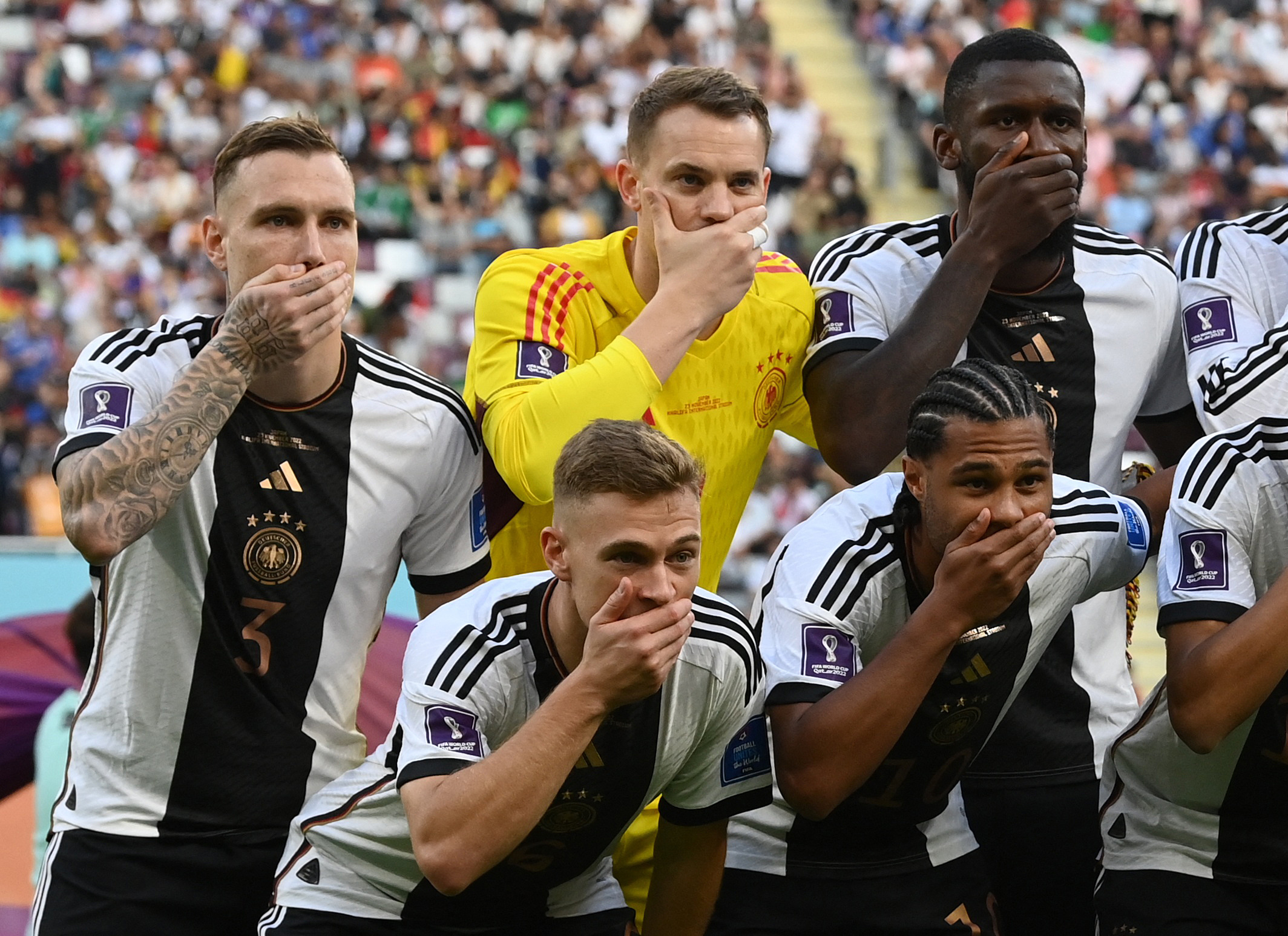 Soccer Football - FIFA World Cup Qatar 2022 - Group E - Germany v Japan - Khalifa International Stadium, Doha, Qatar - November 23, 2022 Germany players cover their mouths as they pose for a team group photo before the match REUTERS