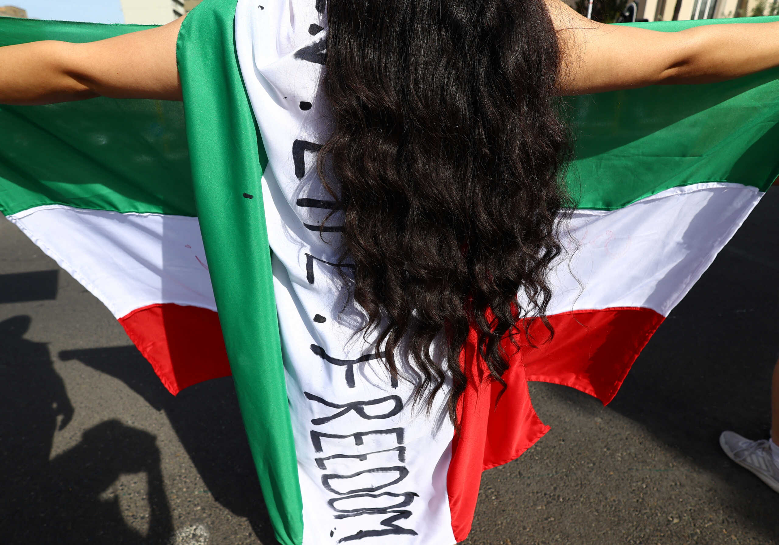A demonstrator holds an Iranian flag during a protest in support of Iranian women and against the death of Mahsa Amini outside parliament in Cape Town, South Africa, October 29, 2022. REUTERS