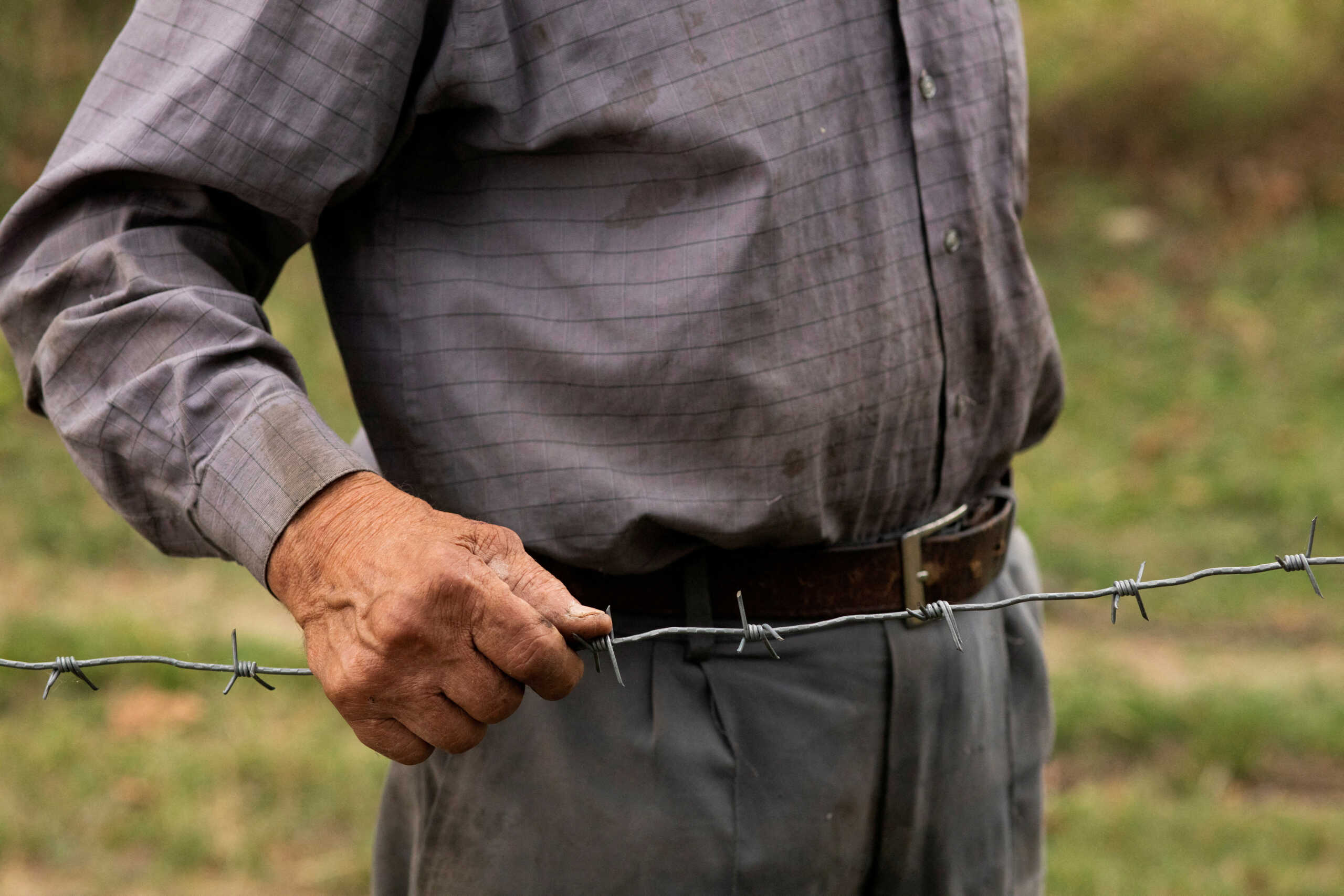 Data Vanishvili, 84, holds on to a piece of a barbed-wire fence at the de facto border of Georgia's breakaway region of South Ossetia, photographed from the village of Khurvaleti, Georgia, October 2, 2018. Vanishvili, his wife and their son woke up in 2013 to find a barbed-wire fence had been erected in the night, putting their home on the Ossetian side of the boundary. He became well-known in Georgia for staying put and defiantly speaking out publicly. Despite the risks, he crosses the boundary to get his pension and to buy food. "I voted in Georgia by going over the occupied border line. When I got home, the Russian soldiers came to my house and jailed me in Tskhinvali. I had to pay a fine to get out. I asked the Georgian police and they helped. They paid 2,000 roubles," said Vanishvili. "Once I shook hands with the president of Ukraine and Georgia over the barbed-wire fence when they paid me a visit from the Georgian-controlled territory. I do not know how the Russians found out, but once that happened, the Russians once again came to my house blackmailing me. I was jailed twice. This is not a life to live. I am confused. I woke up discovering myself not in Georgian-controlled territory, but in the hands of the Russians."       REUTERS