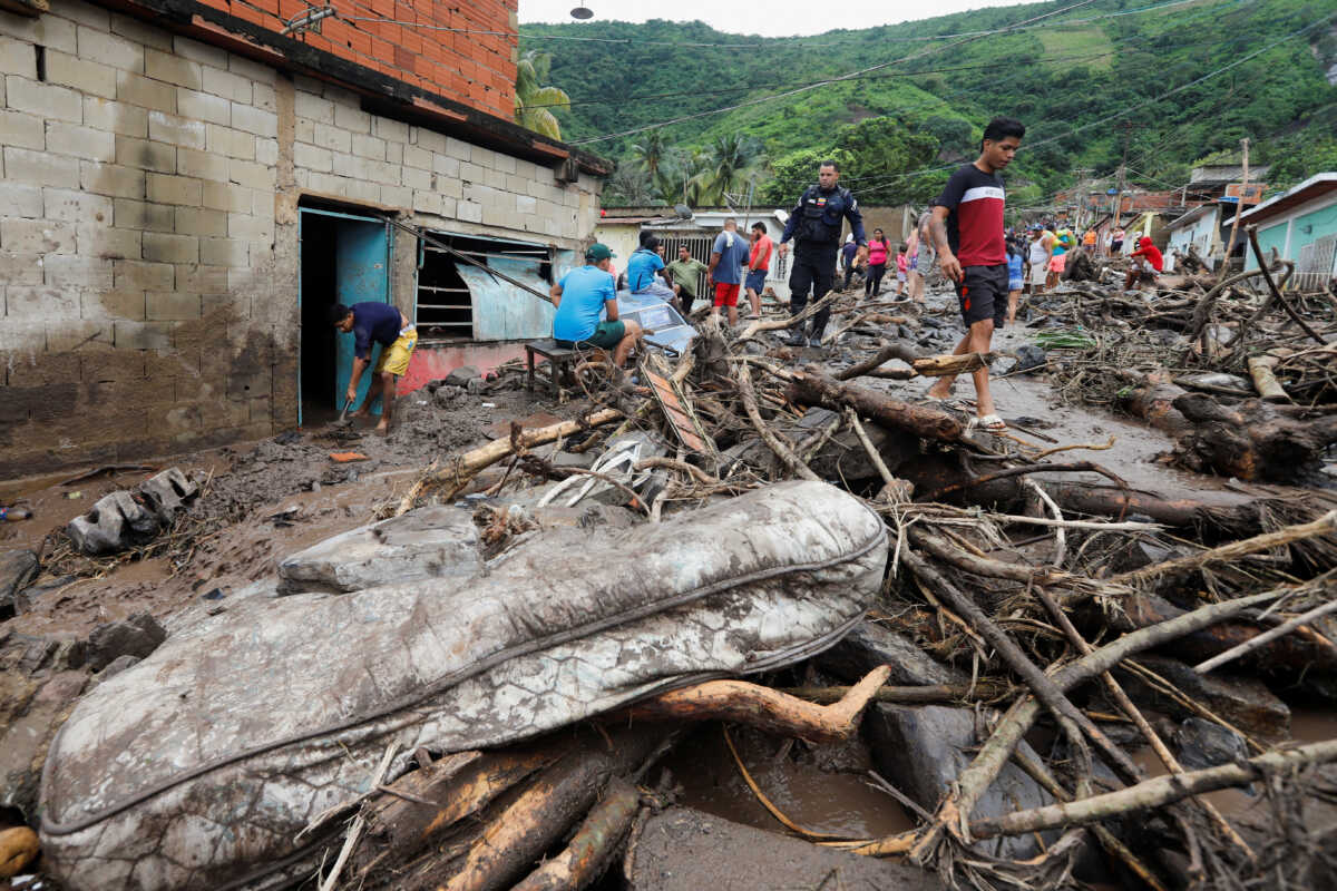 Residents walk through mud in the aftermath of floods caused by heavy rain, in Puerto La Cruz, Venezuela November 4, 2022. REUTERS
