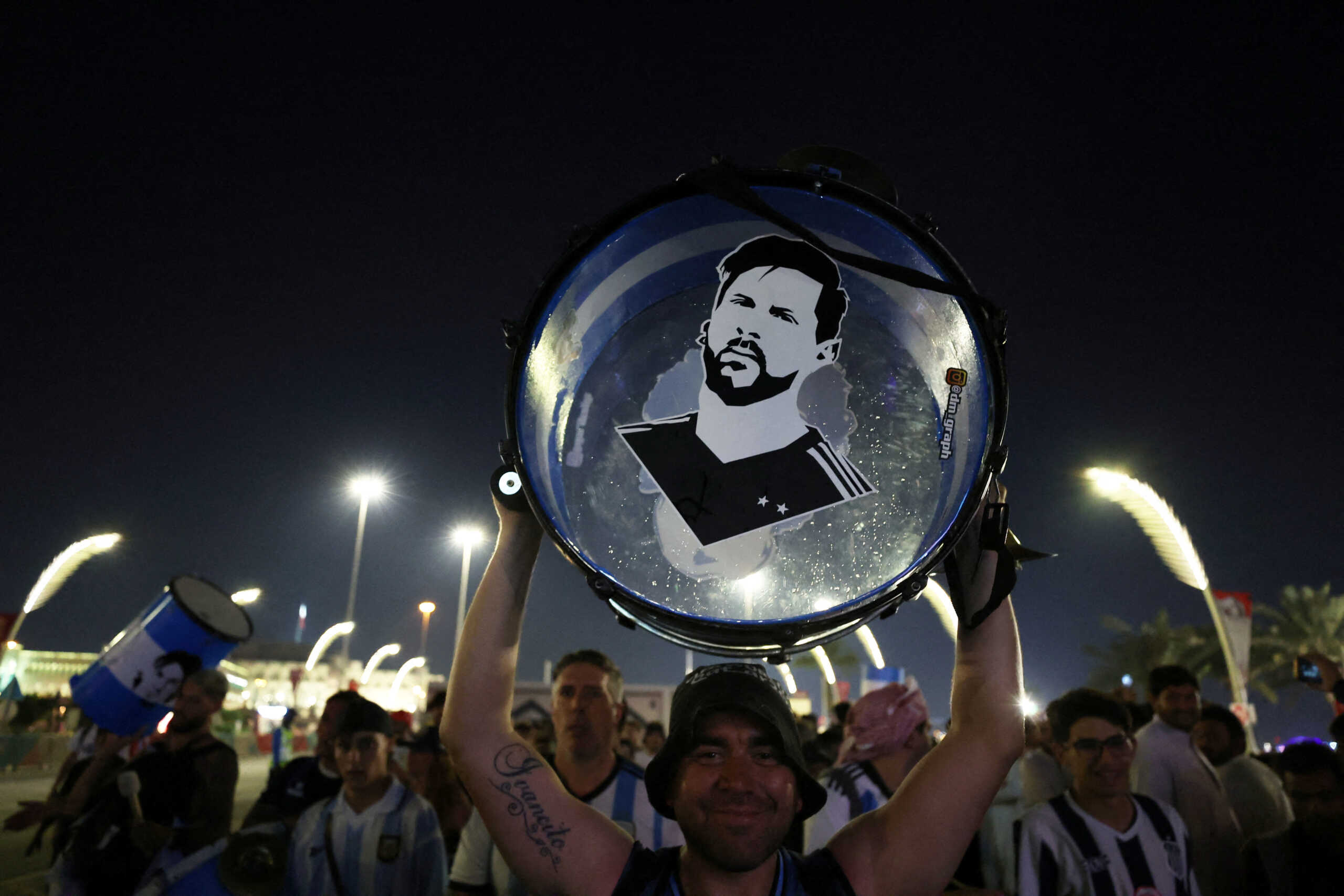 FILE PHOTO: Soccer Football - FIFA World Cup Qatar 2022 - Doha, Qatar - November 25, 2022  An Argentina fan holds up his drum with an image of Lionel Messi on it on the Doha Corniche REUTERS