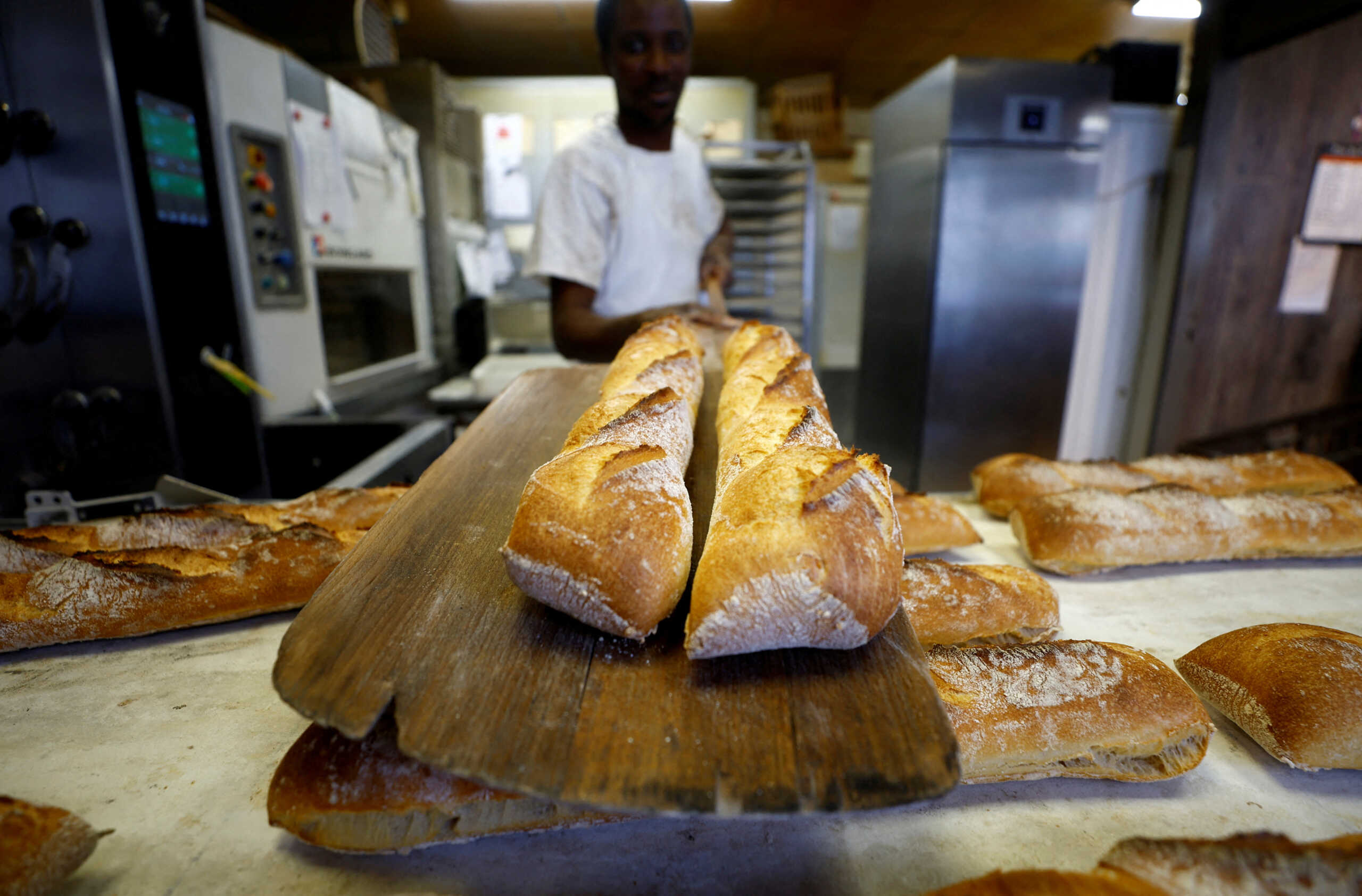 FILE PHOTO: A baker shows freshly-baked?baguettes at "Armand" bakery in Nice, France, November 28, 2022.    REUTERS
