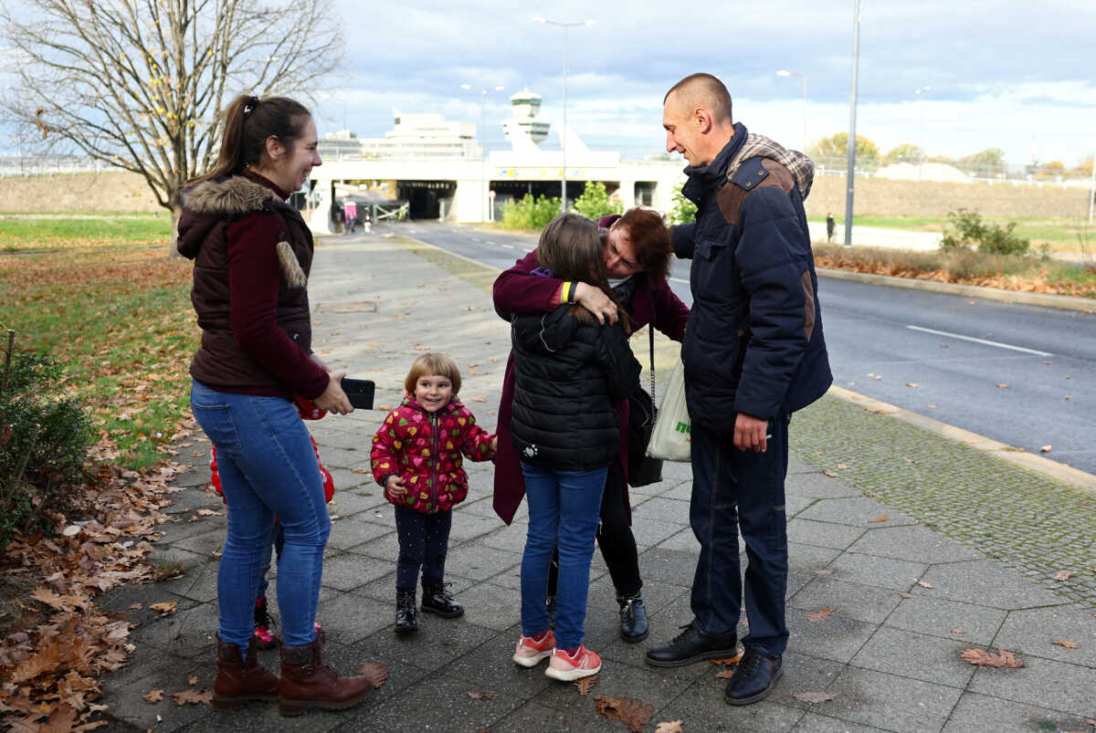 Ivan and Natalia Dombrovskyi and their children welcome his sister Natalia Kovtun who was fleeing from Zaporizhzhia last week, outside an arrival and accommodation centre for refugees, including Ukrainians, in front of former airport Tegel in Berlin, Germany November 9, 2022. REUTERS