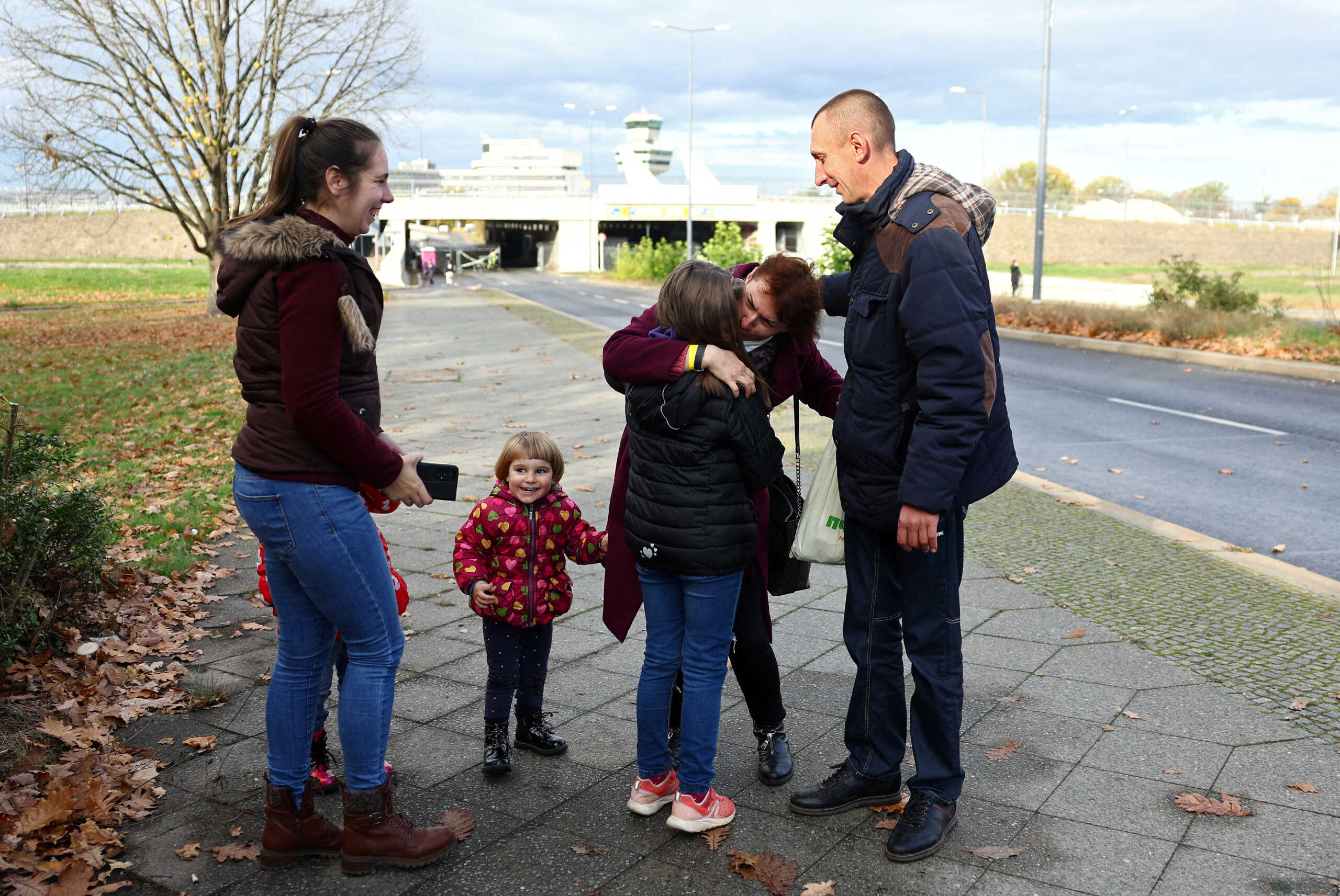 Ivan and Natalia Dombrovskyi and their children welcome his sister Natalia Kovtun who was fleeing from Zaporizhzhia last week, outside an arrival and accommodation centre for refugees, including Ukrainians, in front of former airport Tegel in Berlin, Germany November 9, 2022. REUTERS