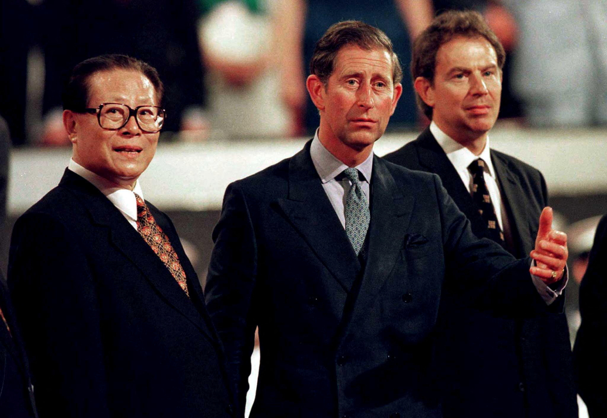 FILE PHOTO: Britain's Prince of Wales shows the way to Chinese President Jiang Zemin as British Prime Minister Tony Blair follows at the end of the ceremony marking the handover of Hong Kong to China July 1, 1997.  REUTERS