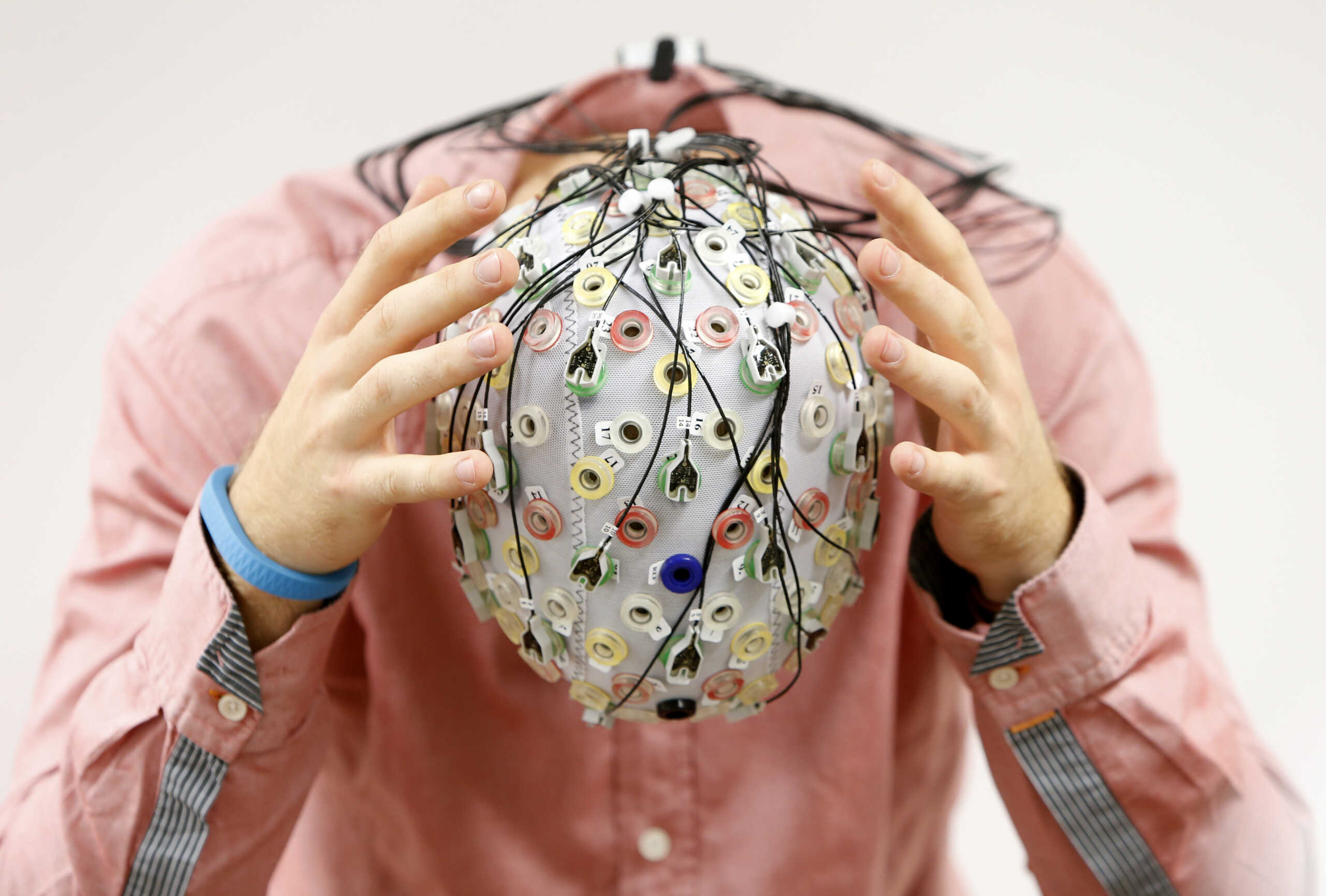 FILE PHOTO: Test person Niklas Thiel poses with an electroencephalography (EEG) cap which measures brain activity, at the Technische Universitaet Muenchen (TUM) in Garching near Munich September 9, 2014.  REUTERS