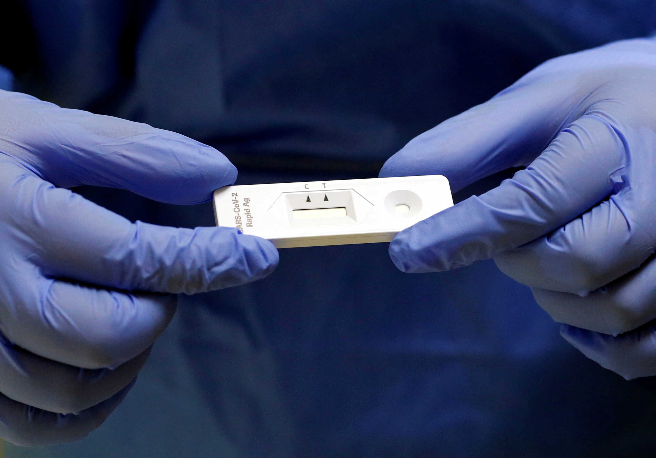 FILE PHOTO: A staff member holds a rapid COVID-19 antigenic test made by Swiss drugmaker Roche, at the smear center of the University Hospital Zurich (USZ), as the spread of the coronavirus disease (COVID-19) continues, in Zurich, Switzerland November 19, 2020. Picture taken November 19, 2020.       REUTERS