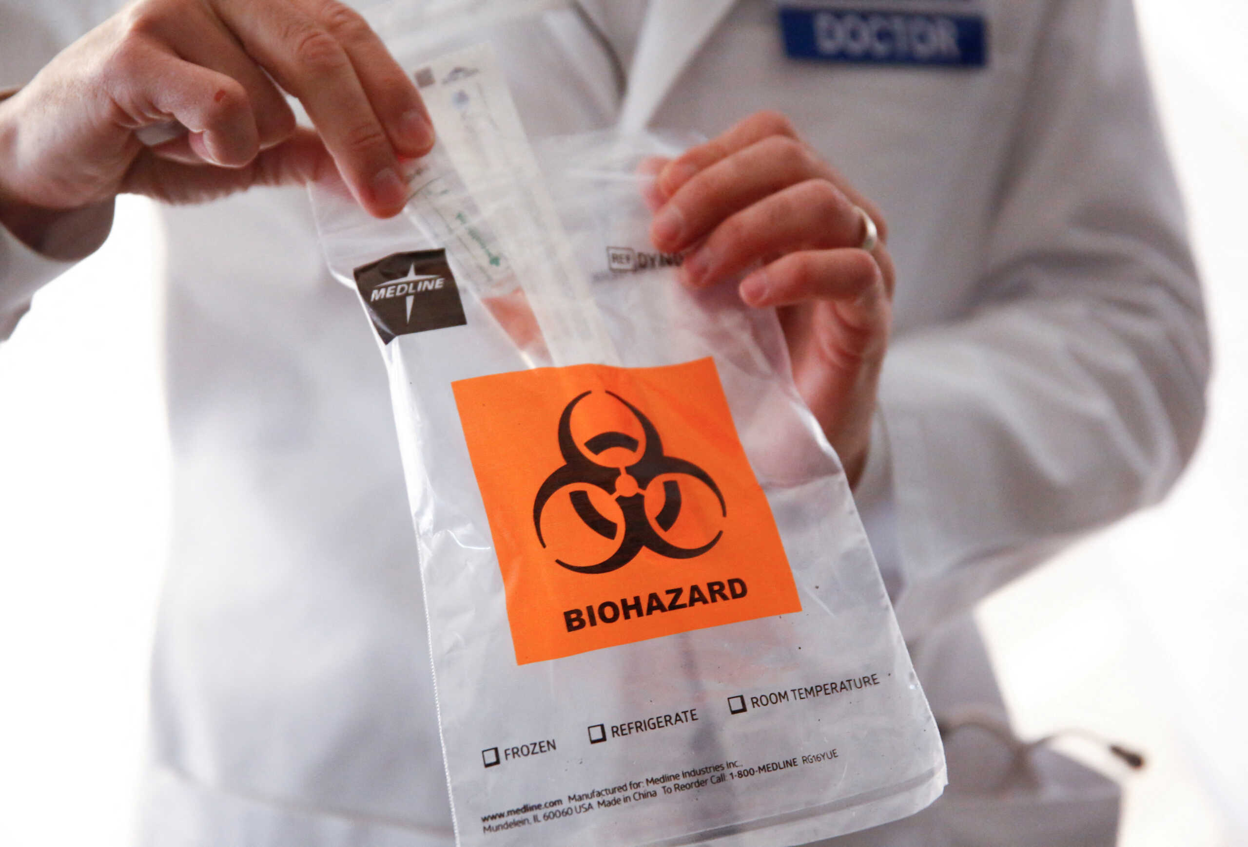 FILE PHOTO: Medical director of infection prevention and employee health Dr. Seth Cohen shows a sample test kit at a drive-through clinic for coronavirus, flu and RSV, at UW Medical Center Northwest in Seattle, Washington, U.S. March 9, 2020. REUTERS