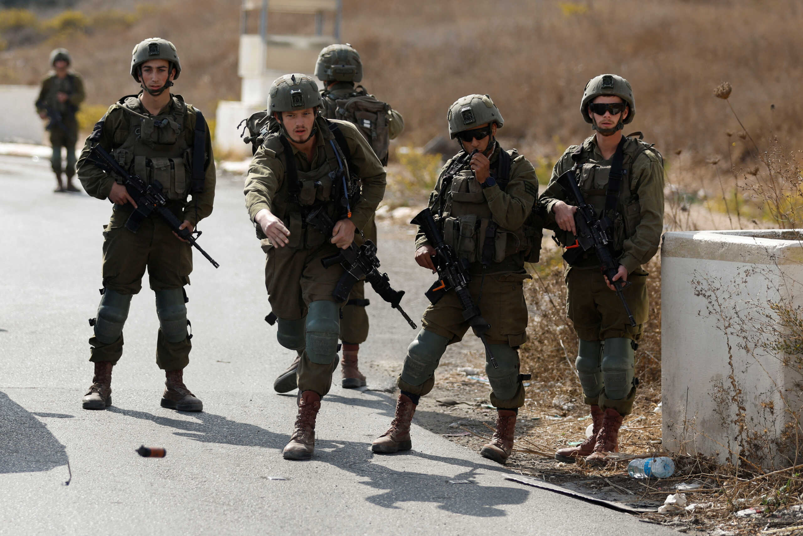 Israeli forces gather during a Palestinian protest demanding Israel to reopen closed roads leading to Nablus, at the Hawara checkpoint near Nablus in the Israeli-occupied West Bank, November 1, 2022. REUTERS