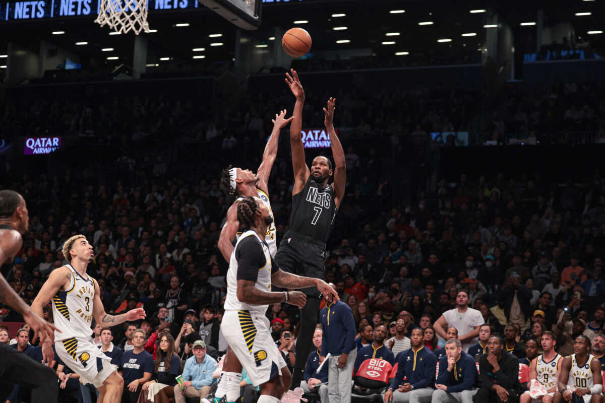 Oct 31, 2022; Brooklyn, New York, USA; Brooklyn Nets forward Kevin Durant (7) shoots the ball against Indiana Pacers guard Buddy Hield (24) and forward James Johnson (16) during the first half at Barclays Center. Mandatory Credit: Vincent Carchietta-USA TODAY Sports