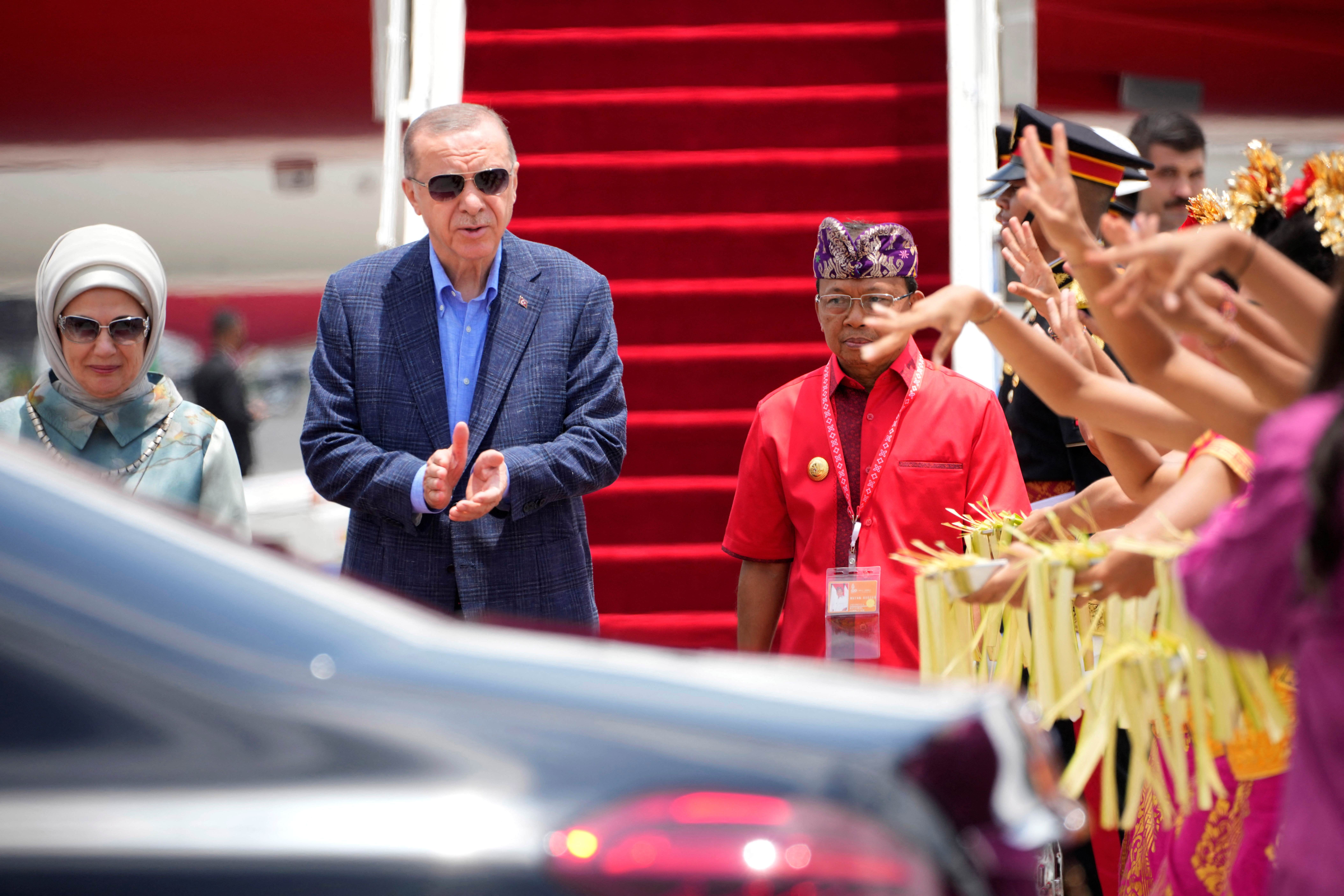 Turkish President Recep Tayyip Erdogan, center, and his wife Emine, left, disembark from their plane upon arrival at Ngurah Rai International Airport ahead of the G20 Summit in Bali, Indonesia, Monday, Nov. 14, 2022.  Firdia Lisnawati