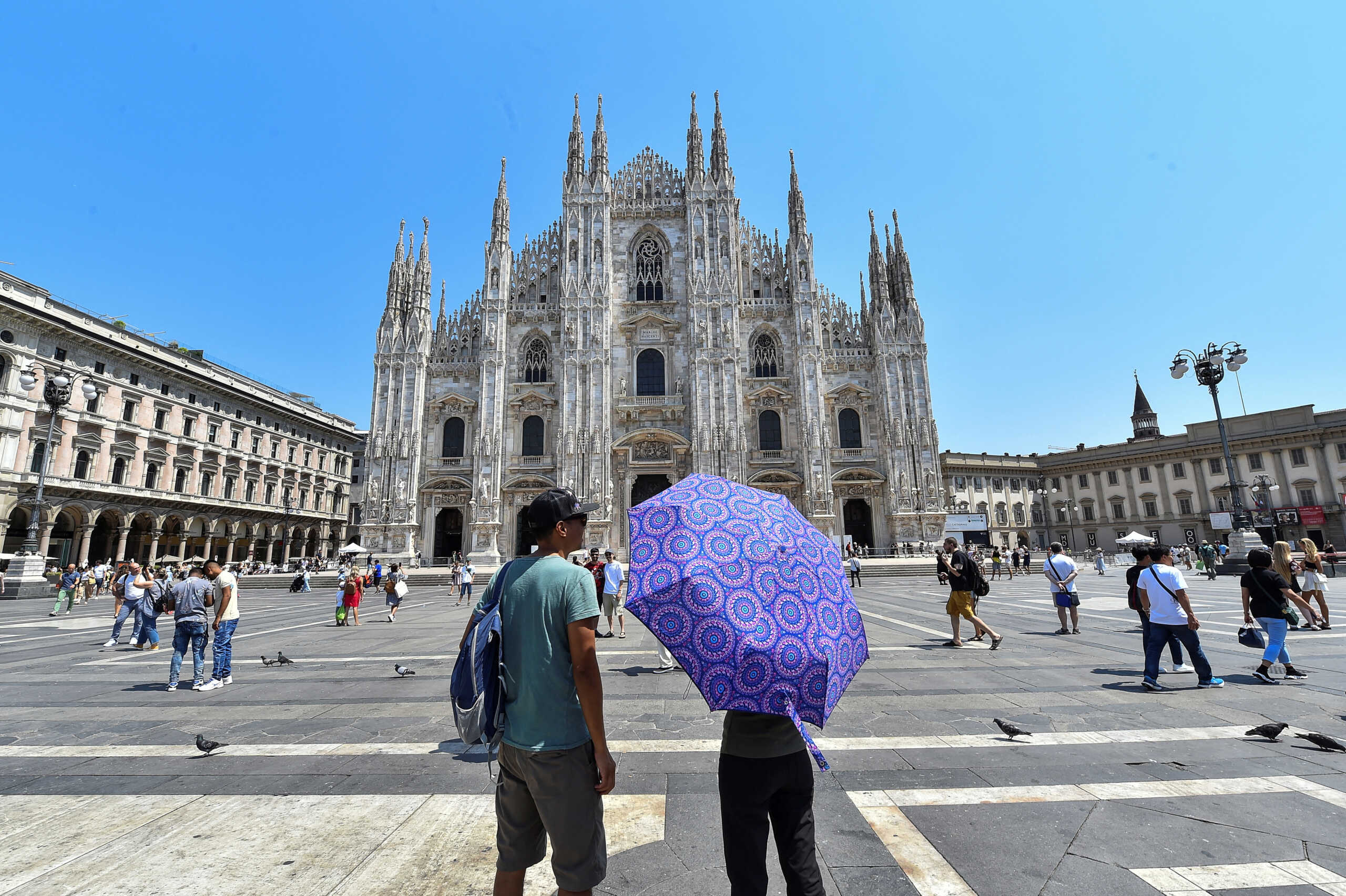 FILE PHOTO: A person holds an umbrella by the Milan's Duomo cathedral at Duomo square, as temperatures soar during a heatwave in Milan, Italy, July 21, 2022. REUTERS