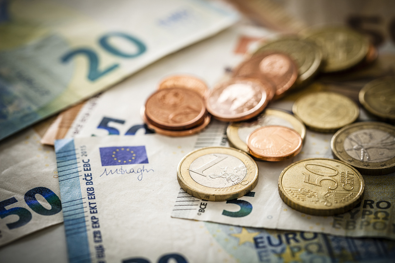 Close up view of European Union banknotes and coins. Selective focus on the one Euro coin. DSRL studio photo taken with Canon EOS 5D Mk II and Canon EF 100mm f