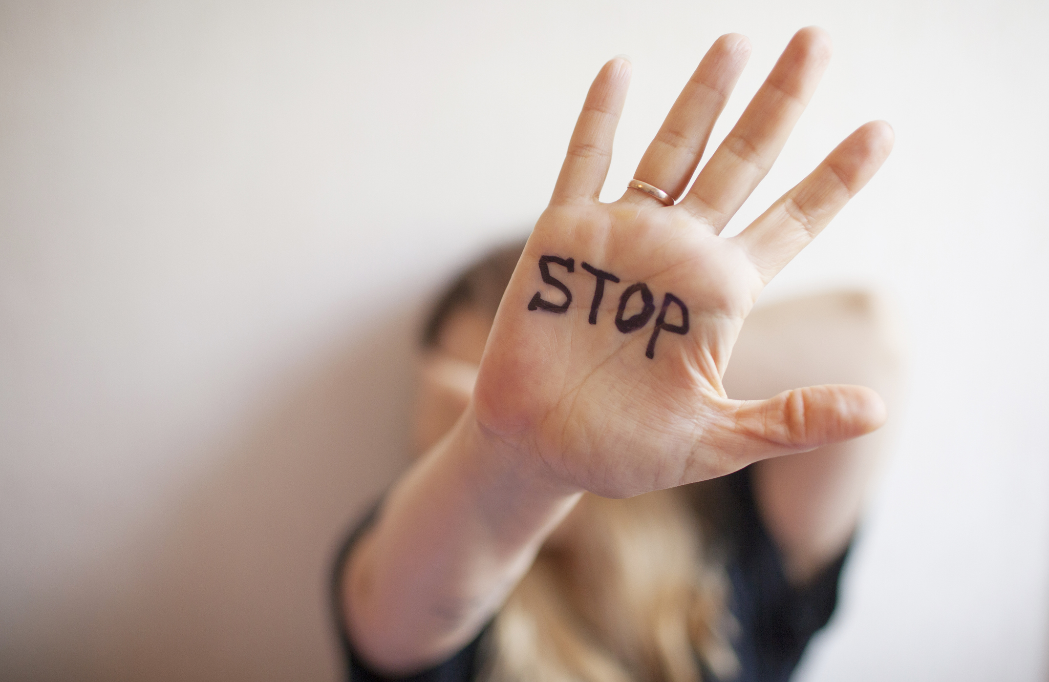Woman shows palm with the inscription on the palm "Stop" isolated